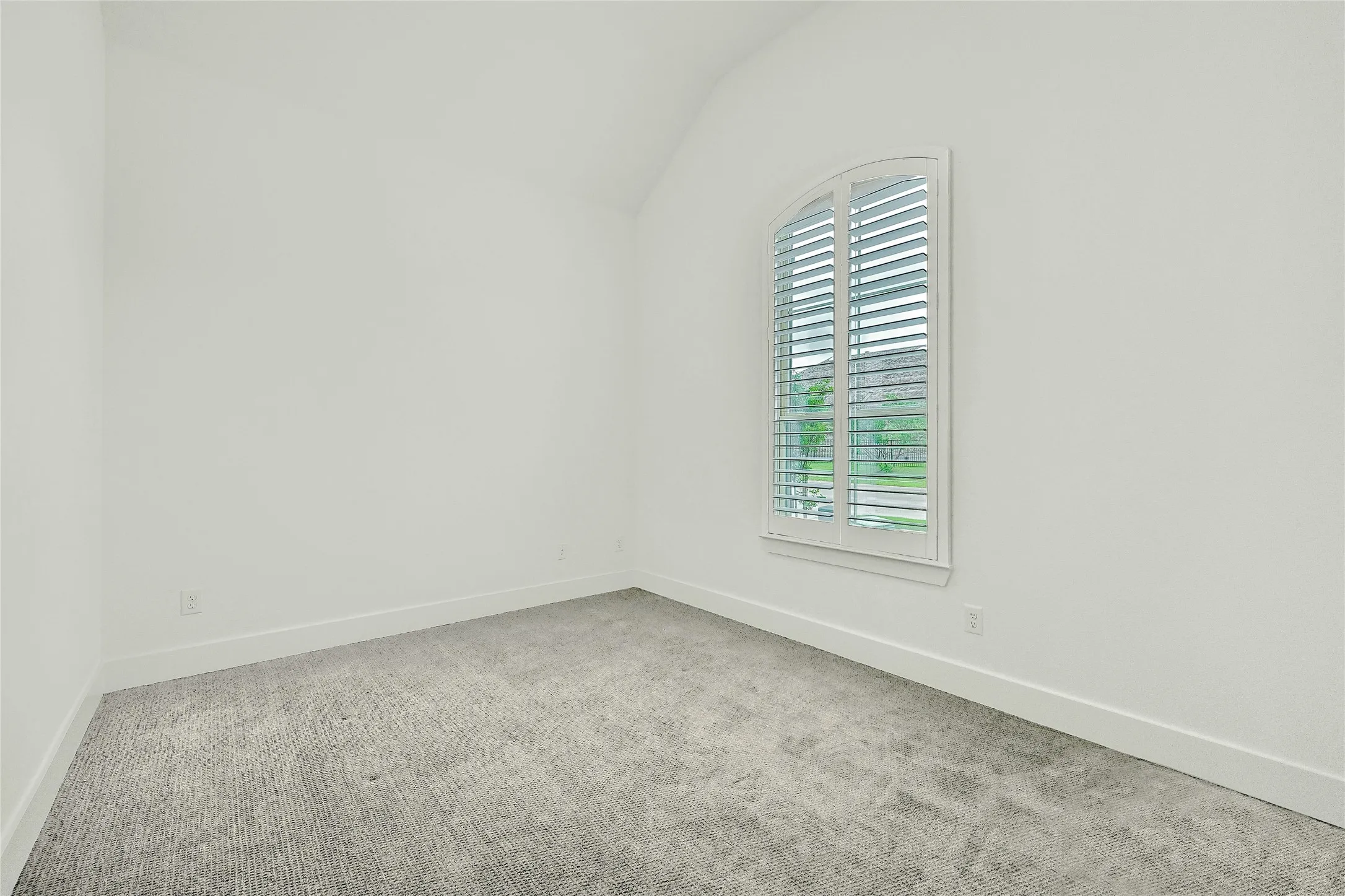 Carpeted empty room with baseboards, vaulted ceiling, and plenty of natural light