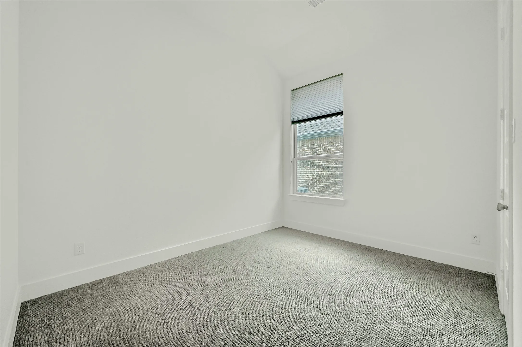Empty room with carpet flooring, baseboards, and vaulted ceiling