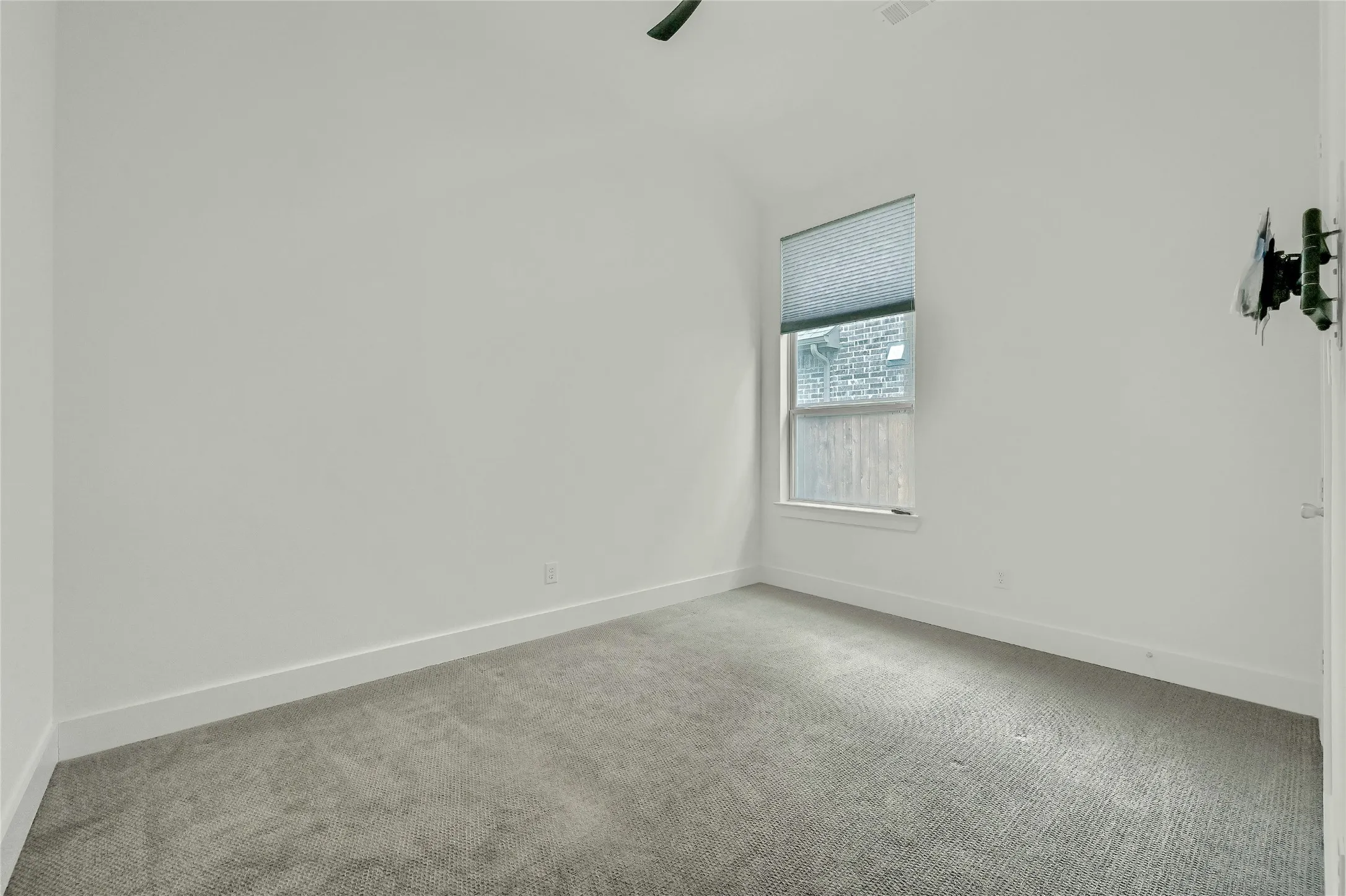 Empty room featuring carpet flooring, baseboards, and visible vents