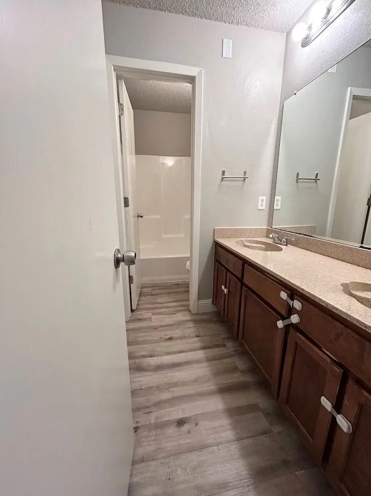 Dual sink vanity with a light-toned countertop and wood-finish cabinetry