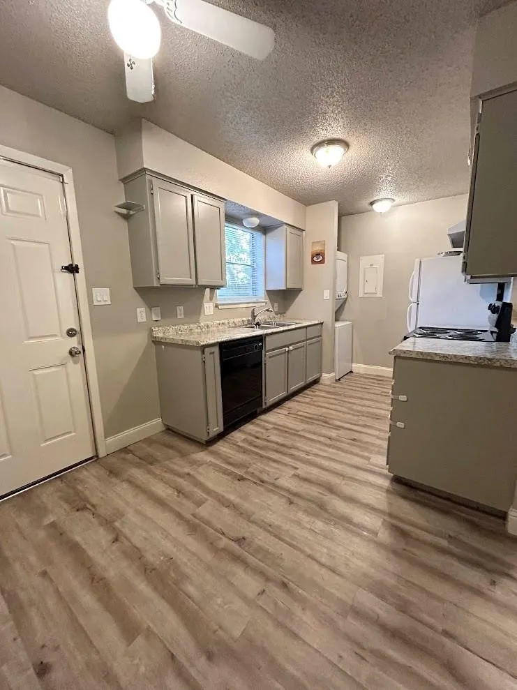 Kitchen featuring wood-finish flooring, light gray cabinetry, and speckled countertops