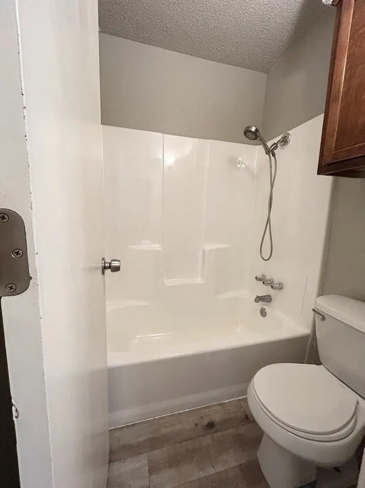Bathroom featuring a white tub and shower combination with a handheld showerhead