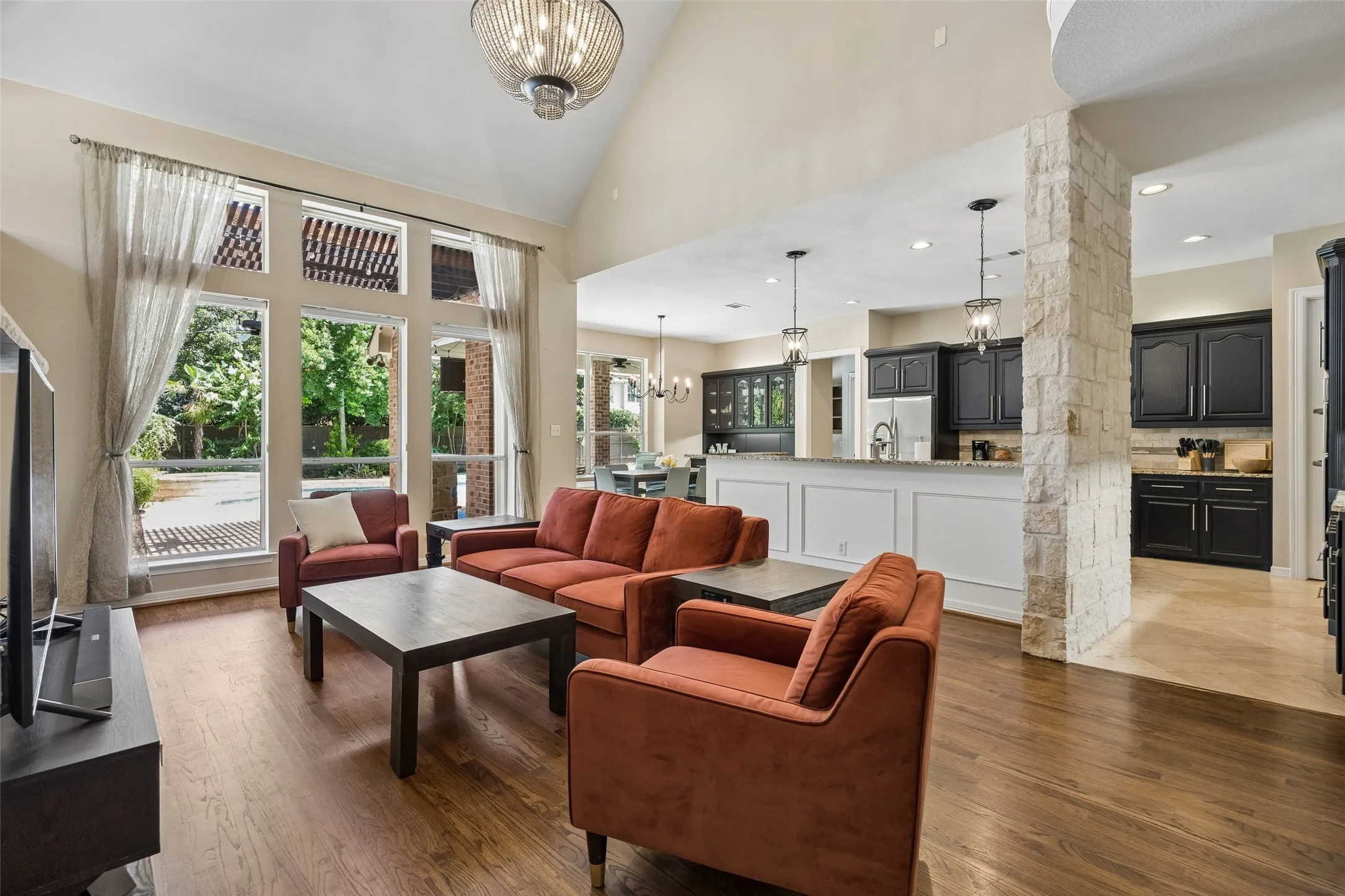 Living area featuring wood-finish flooring, a vaulted ceiling, and an open concept layout