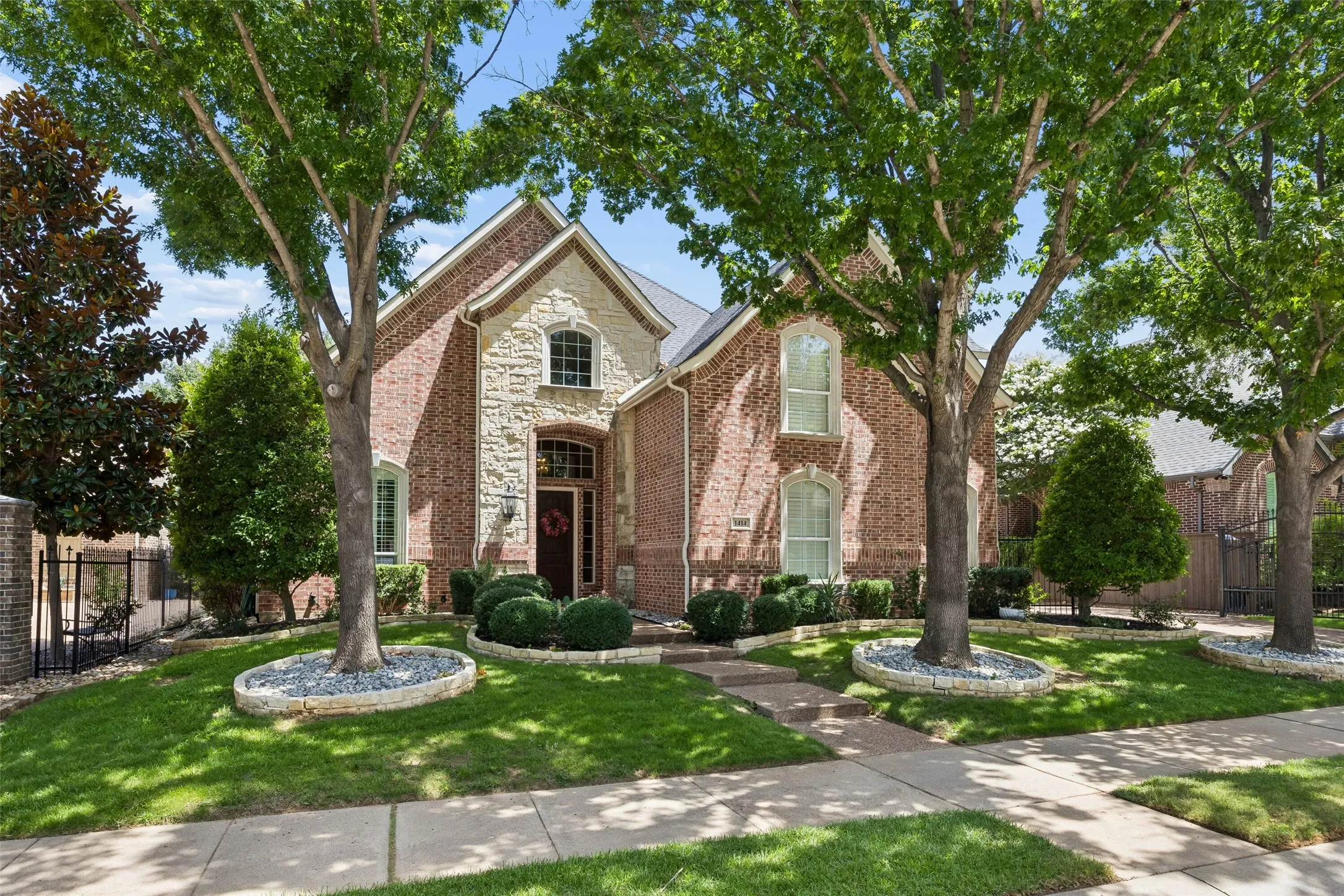Brick and stone facade residence featuring arched and rectangular windows