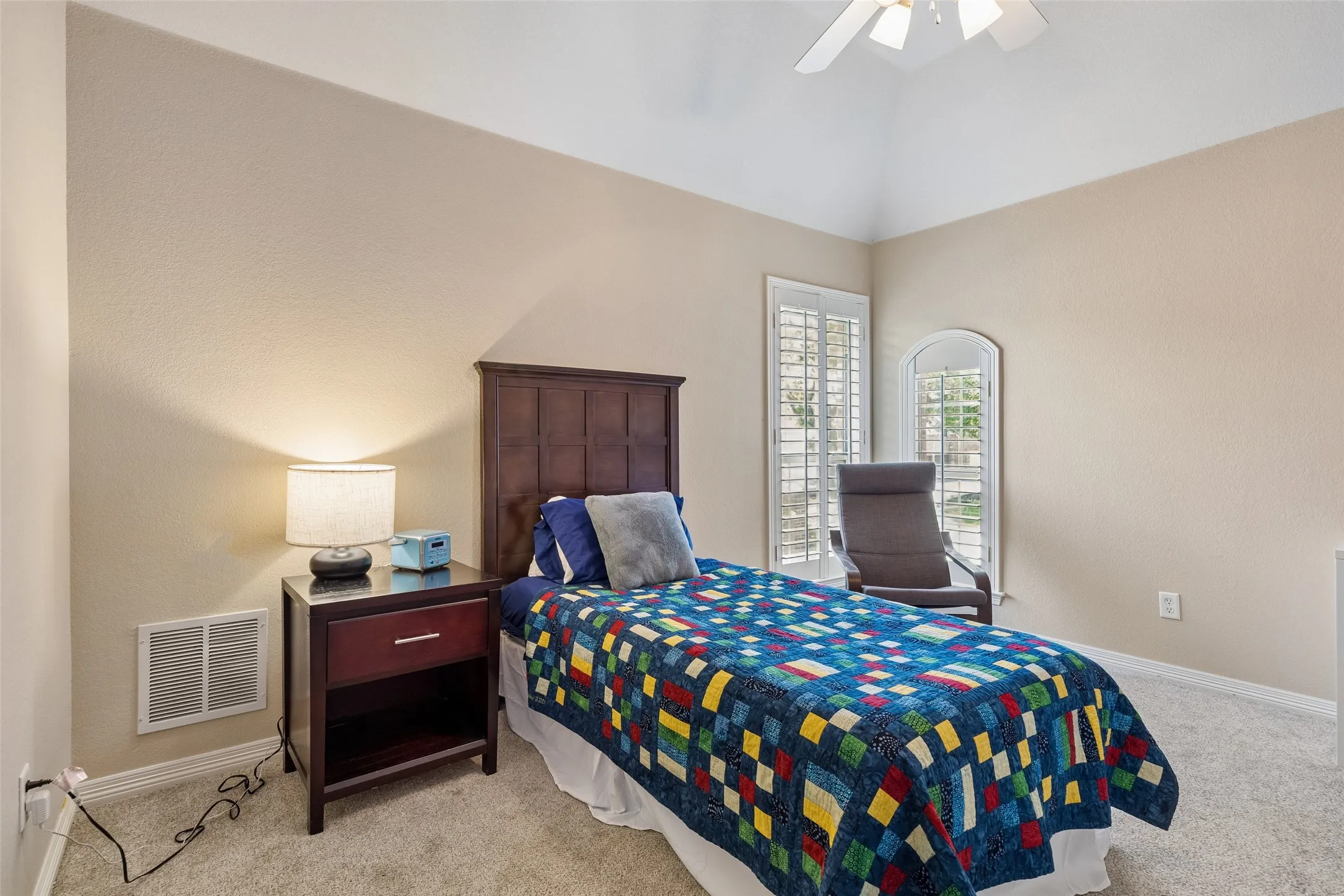 Vaulted ceiling bedroom with a ceiling fan