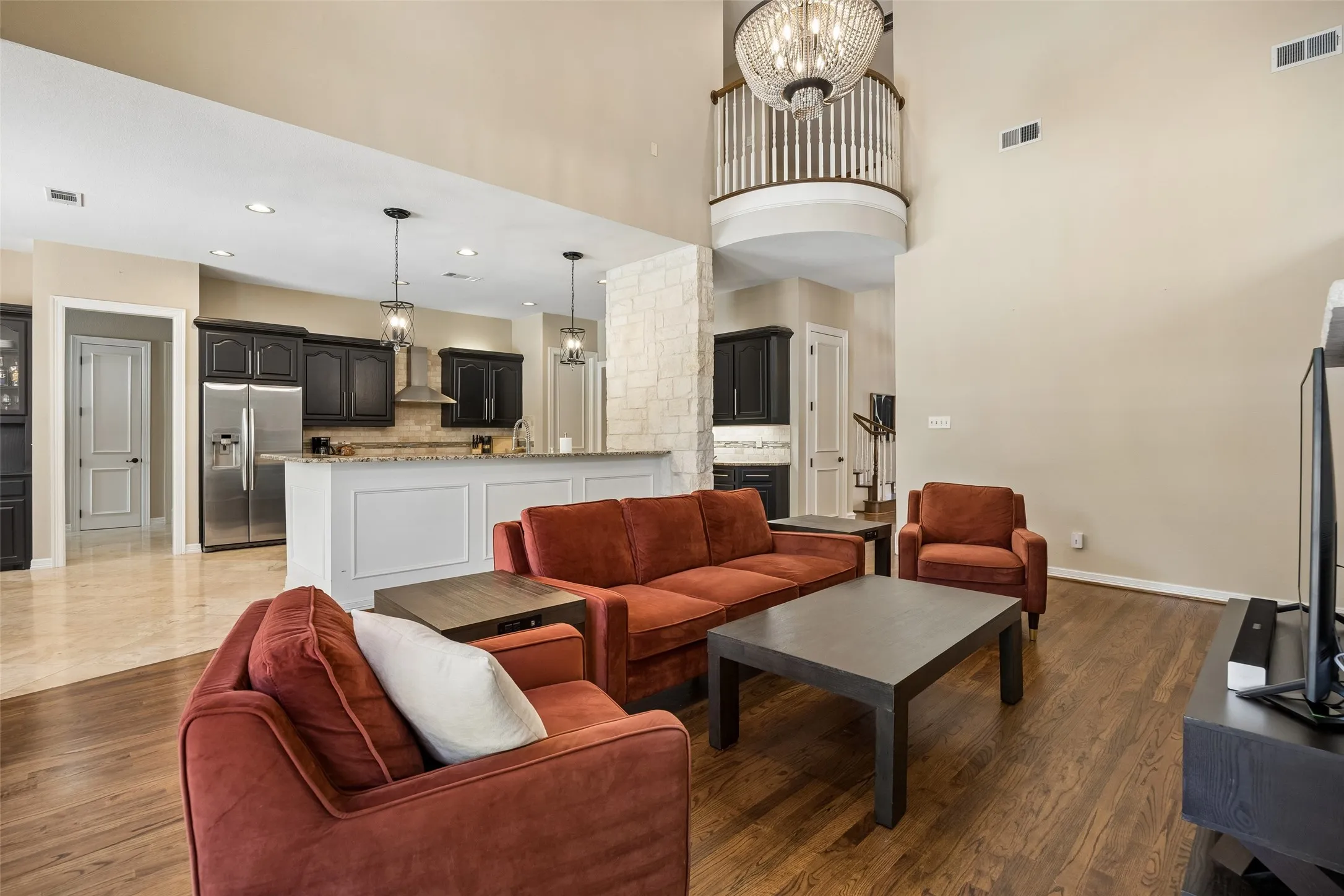 Open-concept living area featuring high ceilings and wood-finish flooring