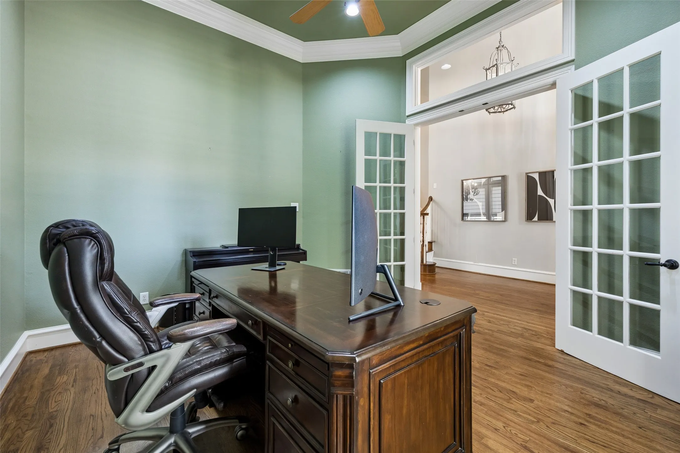 Office space featuring wood-finish flooring, crown molding, a ceiling fan, and French doors