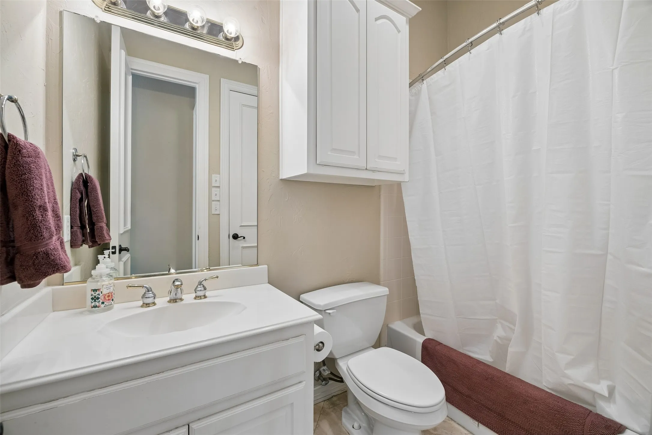 Bathroom vanity with an integrated sink, polished chrome faucet, and a large mirror