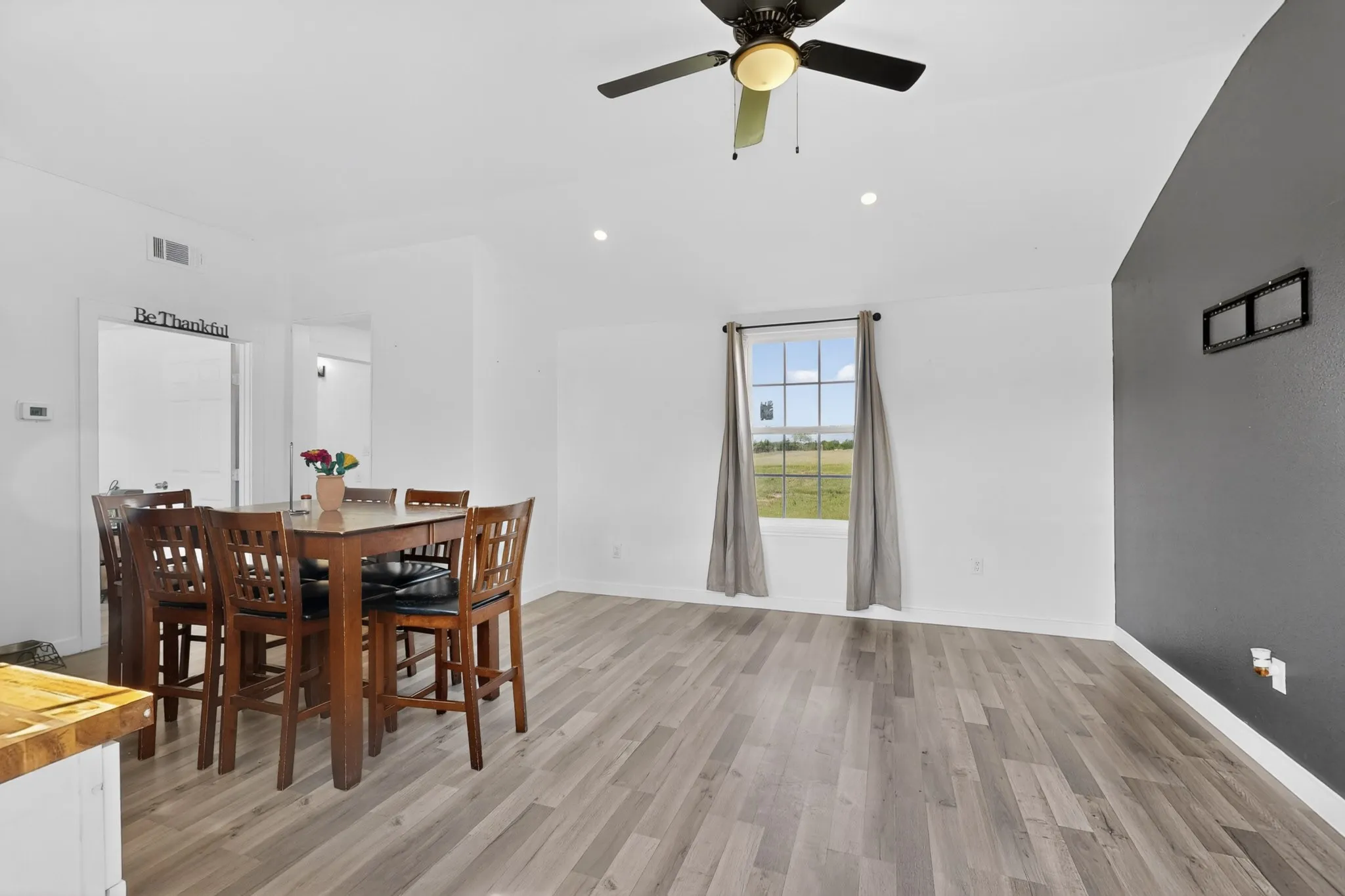 Spacious room featuring wood-finish flooring, recessed lighting, and a ceiling fan