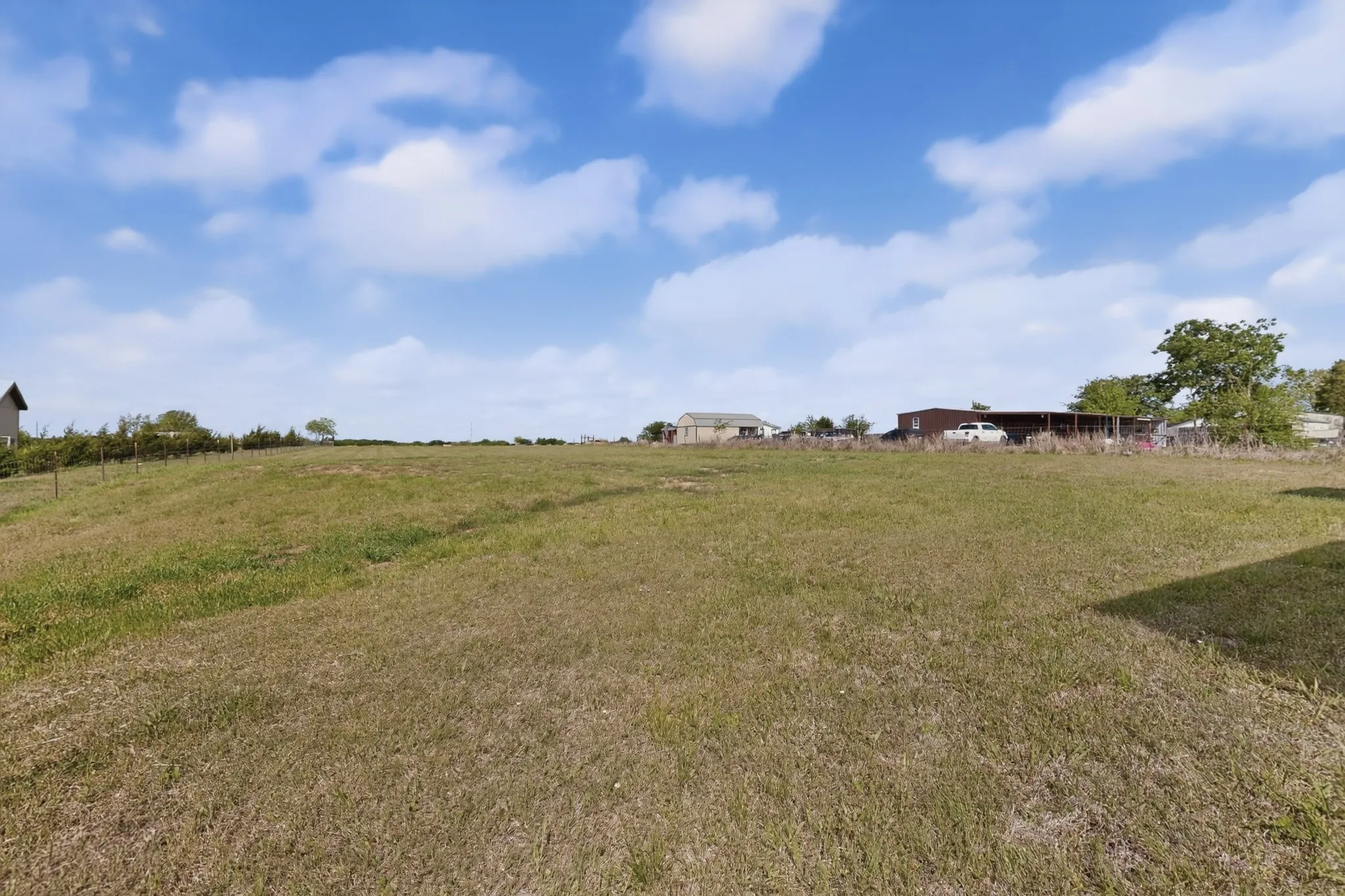 Expansive open lot featuring a gentle slope and natural ground cover