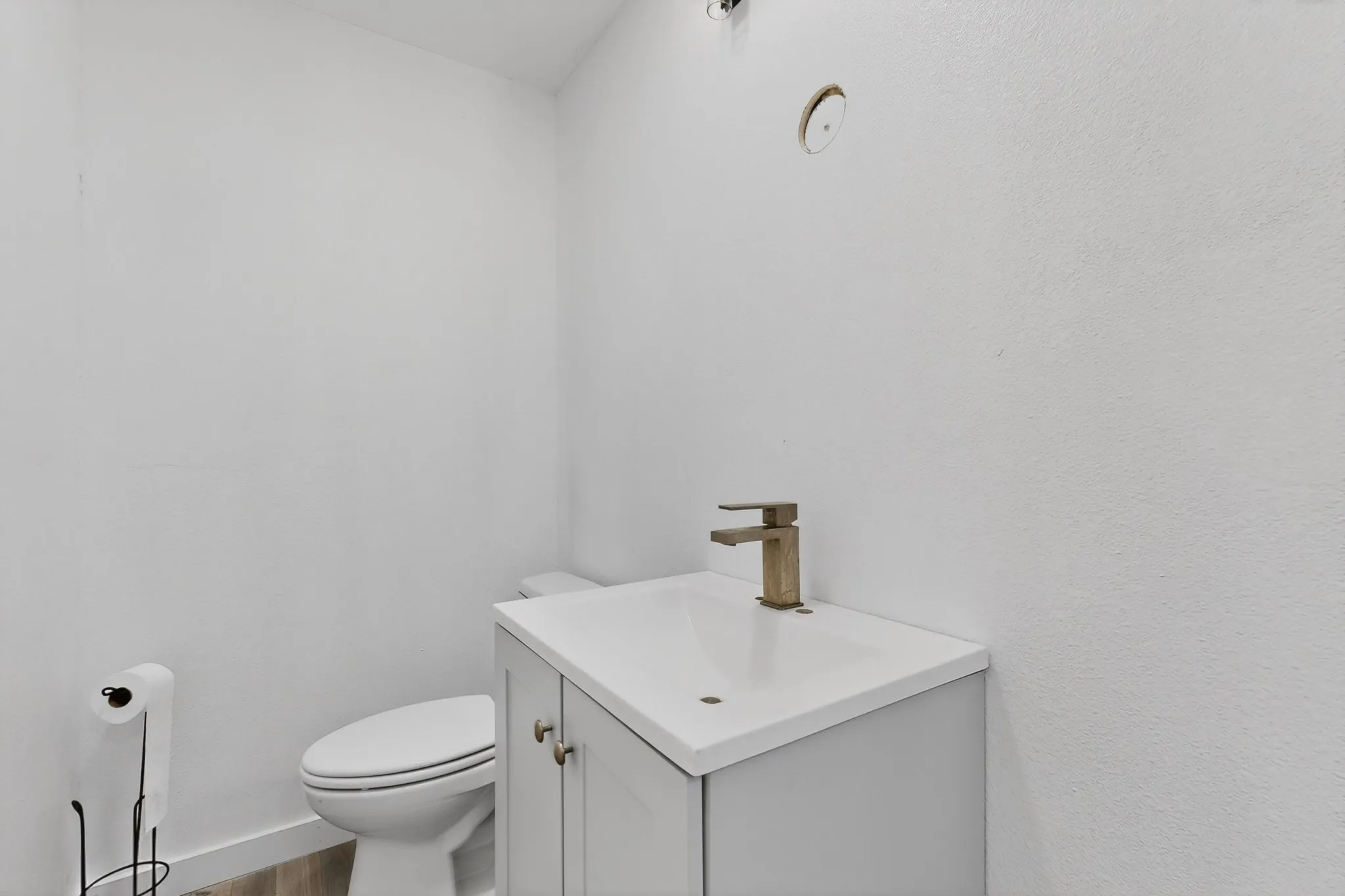 White vanity with an integrated sink and bronze-finish faucet