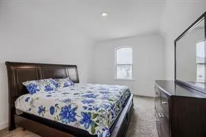 Carpeted room with white walls, an arched window, and recessed lighting