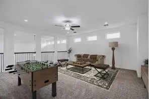 Spacious loft area featuring carpet flooring, recessed lighting, and a ceiling fan