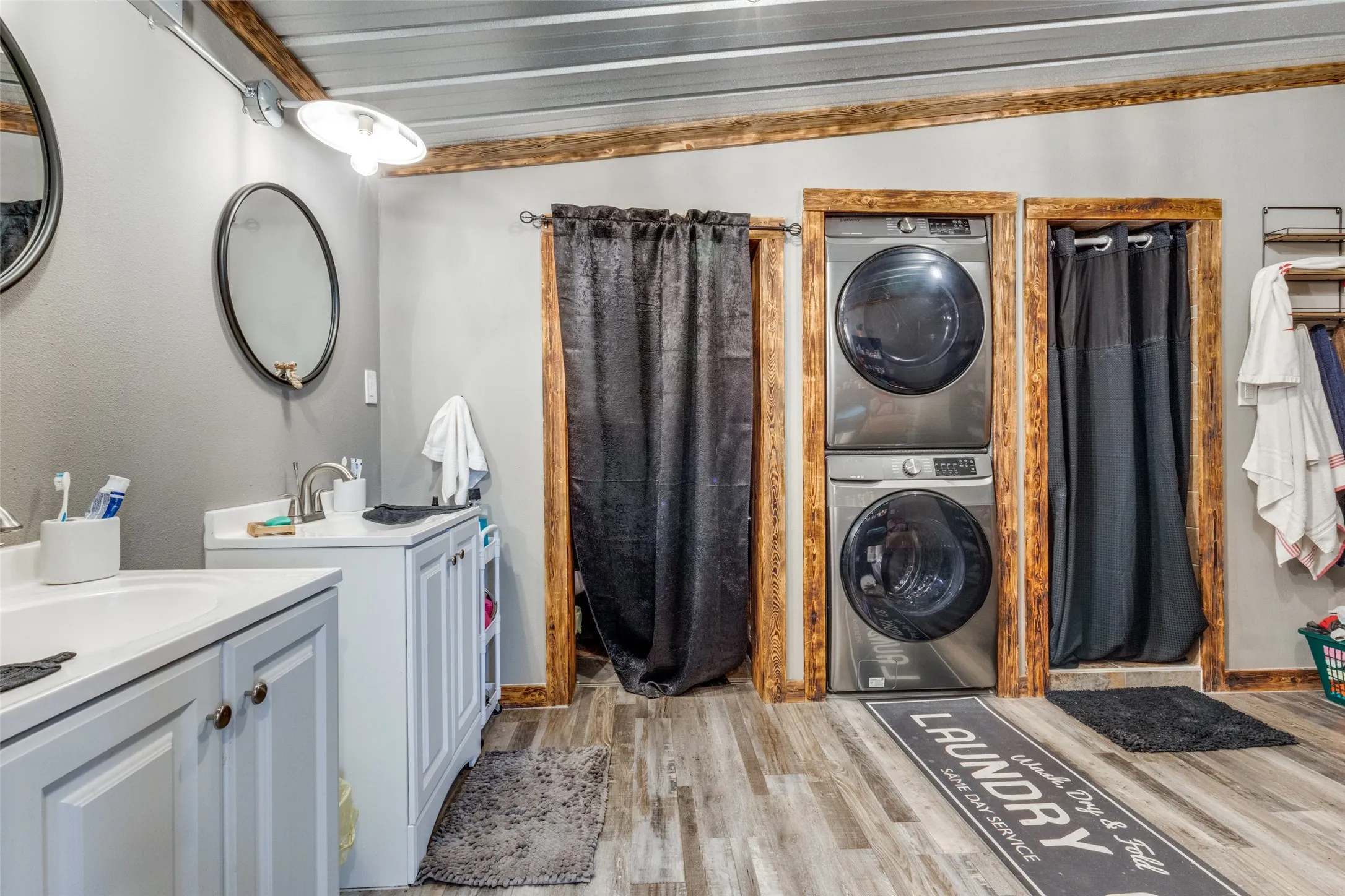 Laundry room featuring light wood-style flooring and estacked washer and dryer