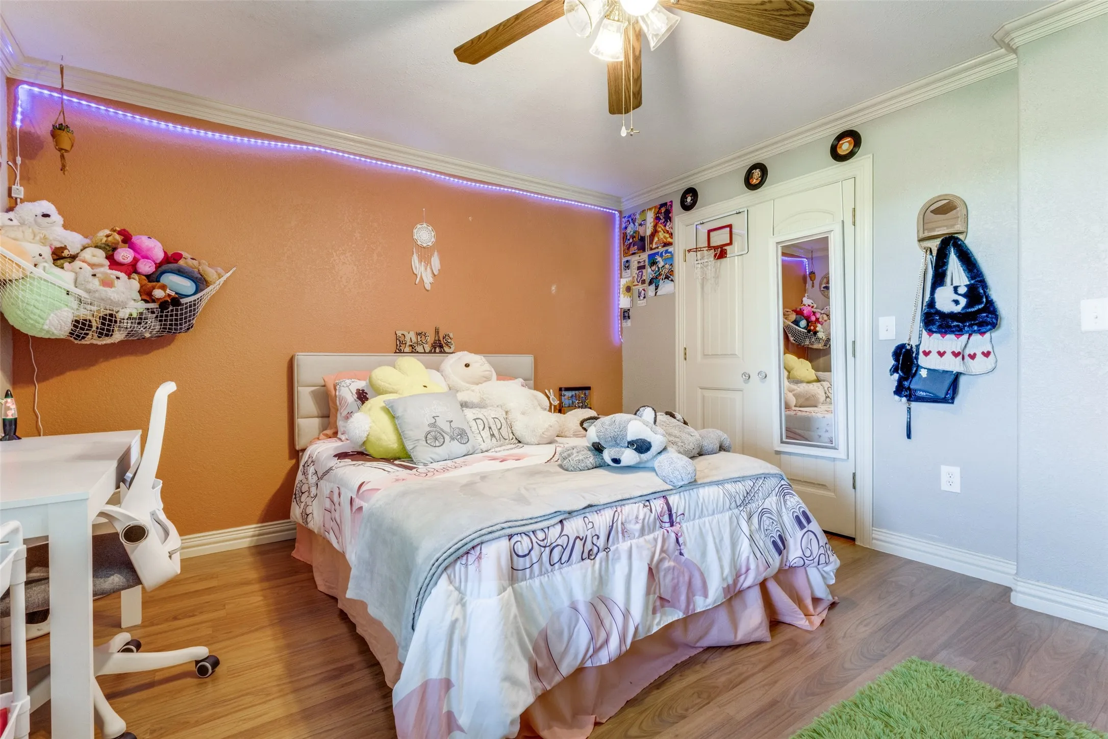 Bedroom featuring wood finished floors, crown molding, and ceiling fan
