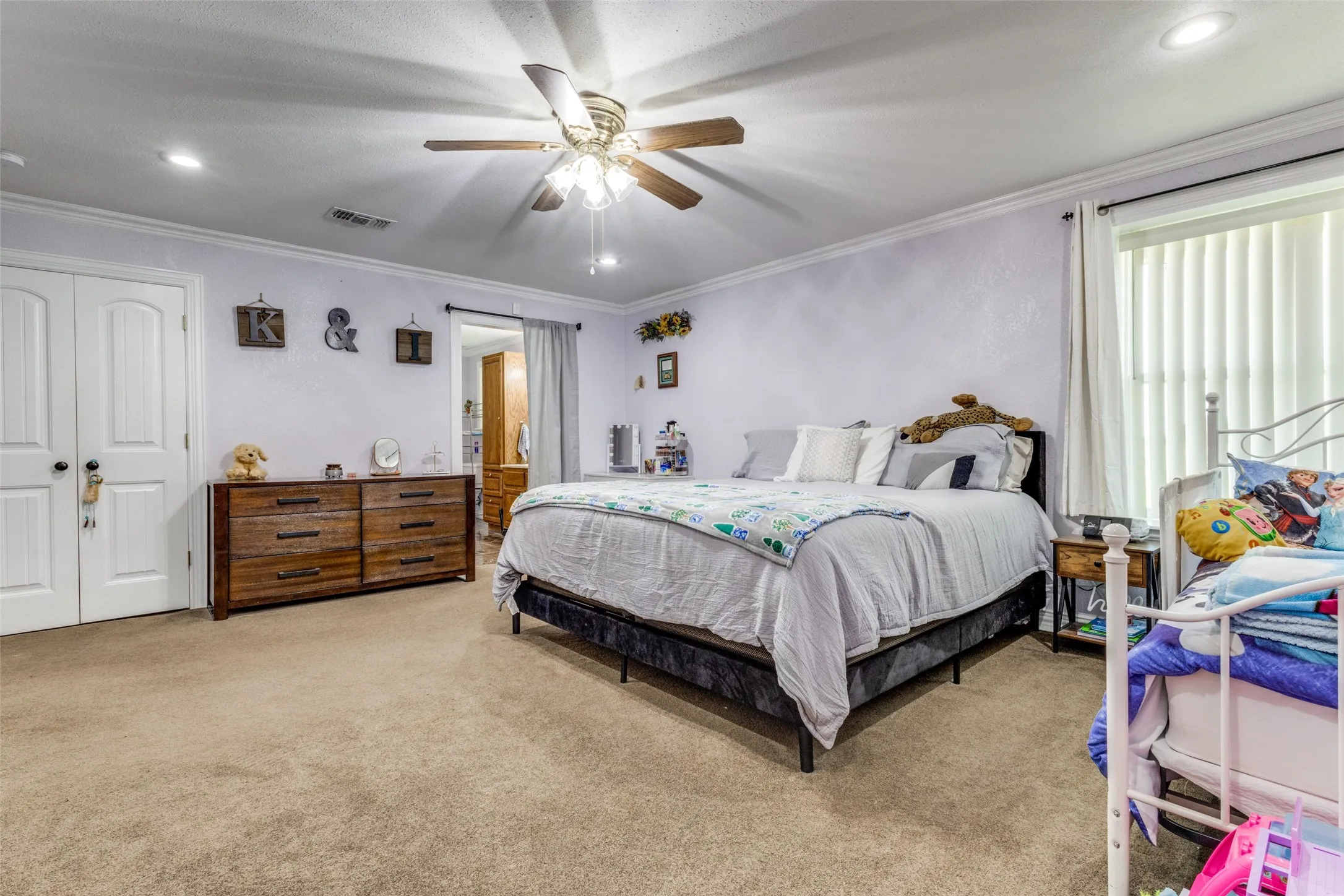 Carpeted bedroom featuring recessed lighting, crown molding, a ceiling fan, and a closet