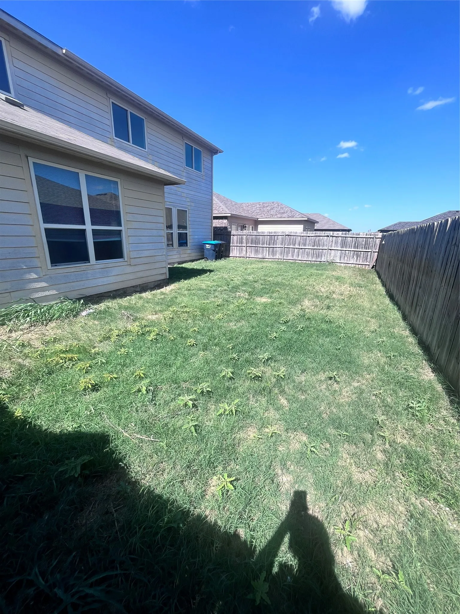 Expansive rear yard featuring a wooden privacy fence and established lawn