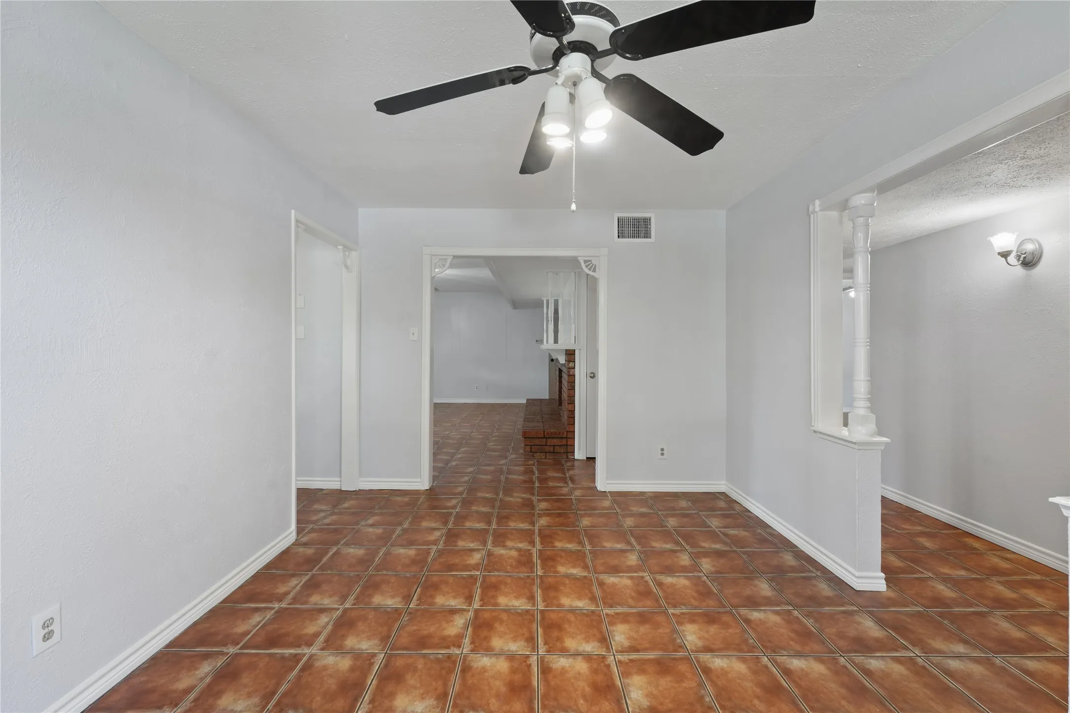 Tiled spare room featuring ceiling fan
