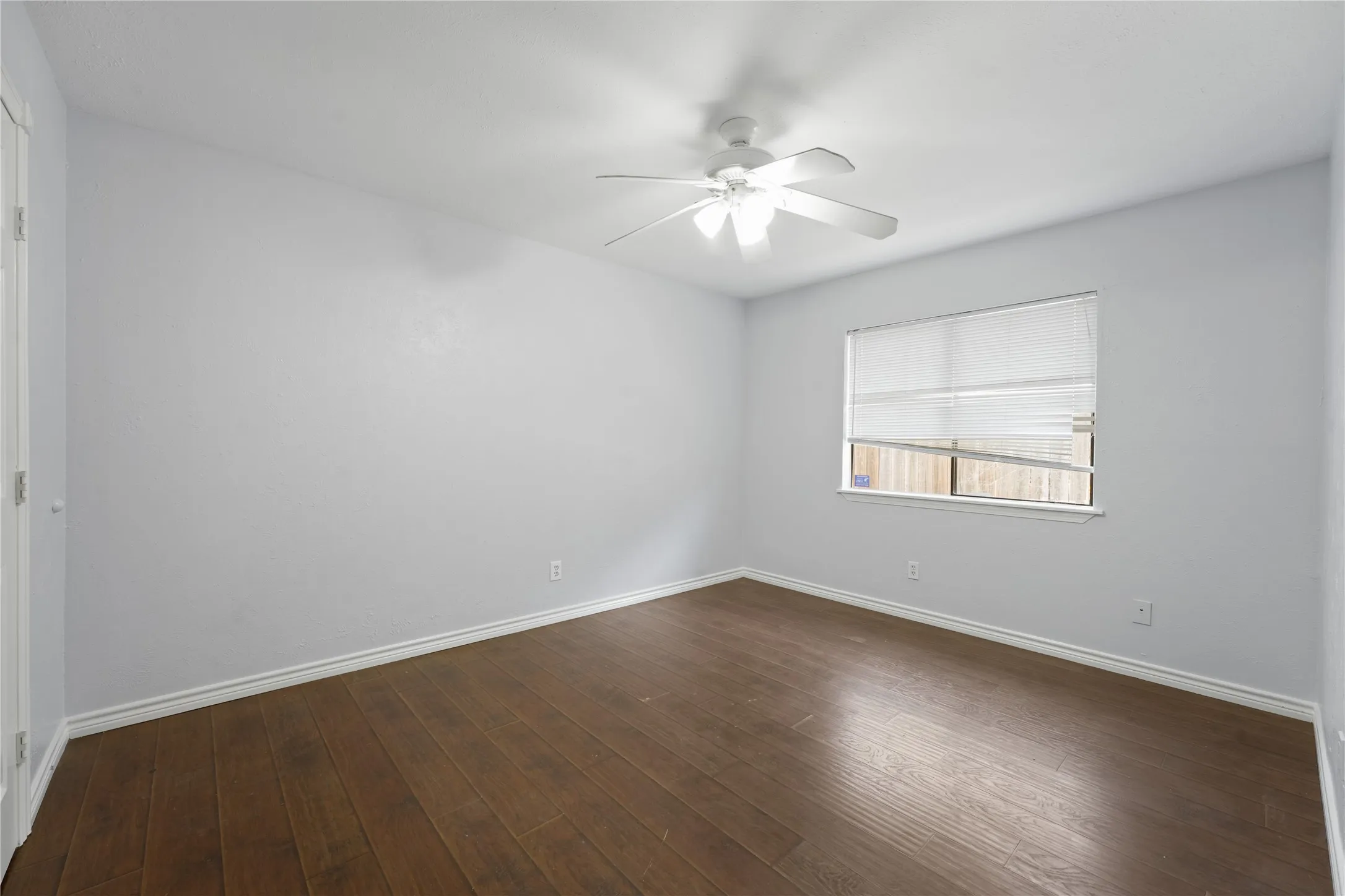 Spare room featuring ceiling fan and dark hardwood / wood-style floors