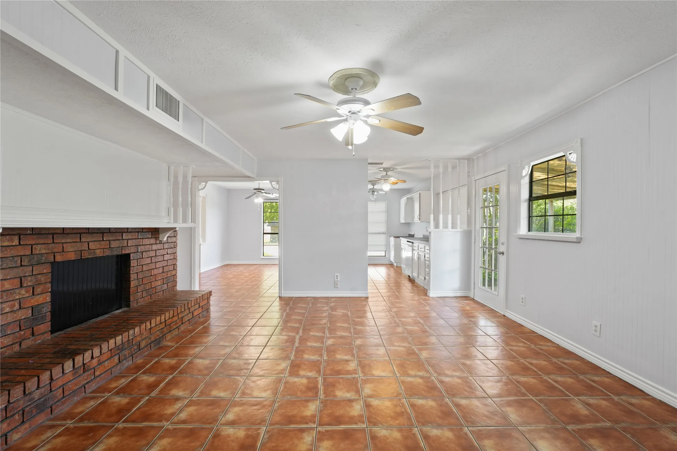 Unfurnished living room featuring tile floors, ceiling fan, and a fireplace