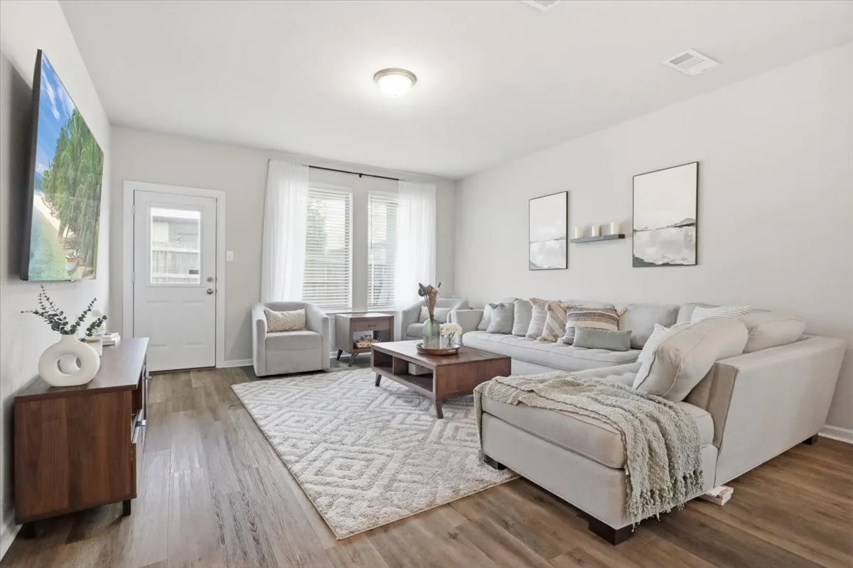 Recessed lighting illuminates wood-finish flooring
