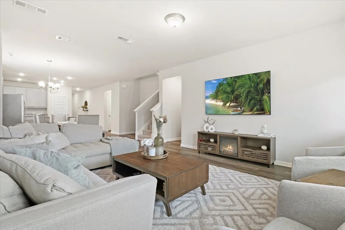 Open-concept living area featuring wood-finish flooring and a built-in electric fireplace