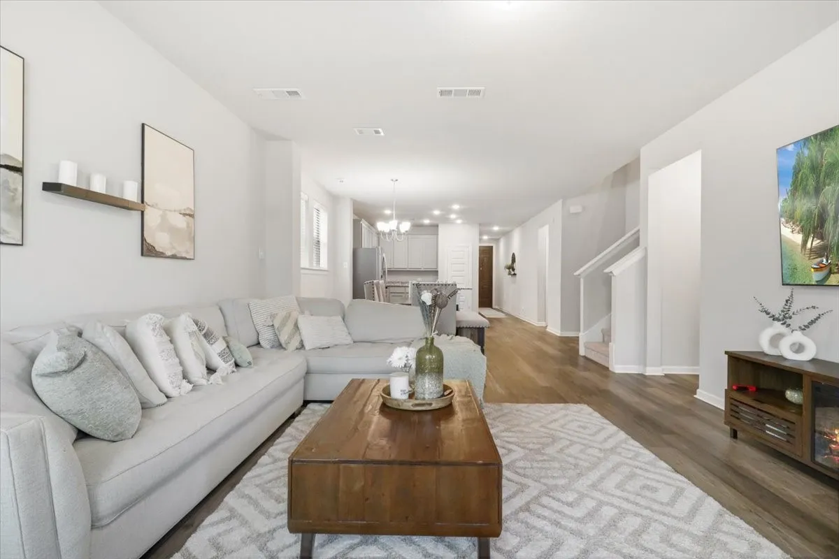 Open-concept living area featuring wood-finish flooring, recessed lighting, and a neutral color palette