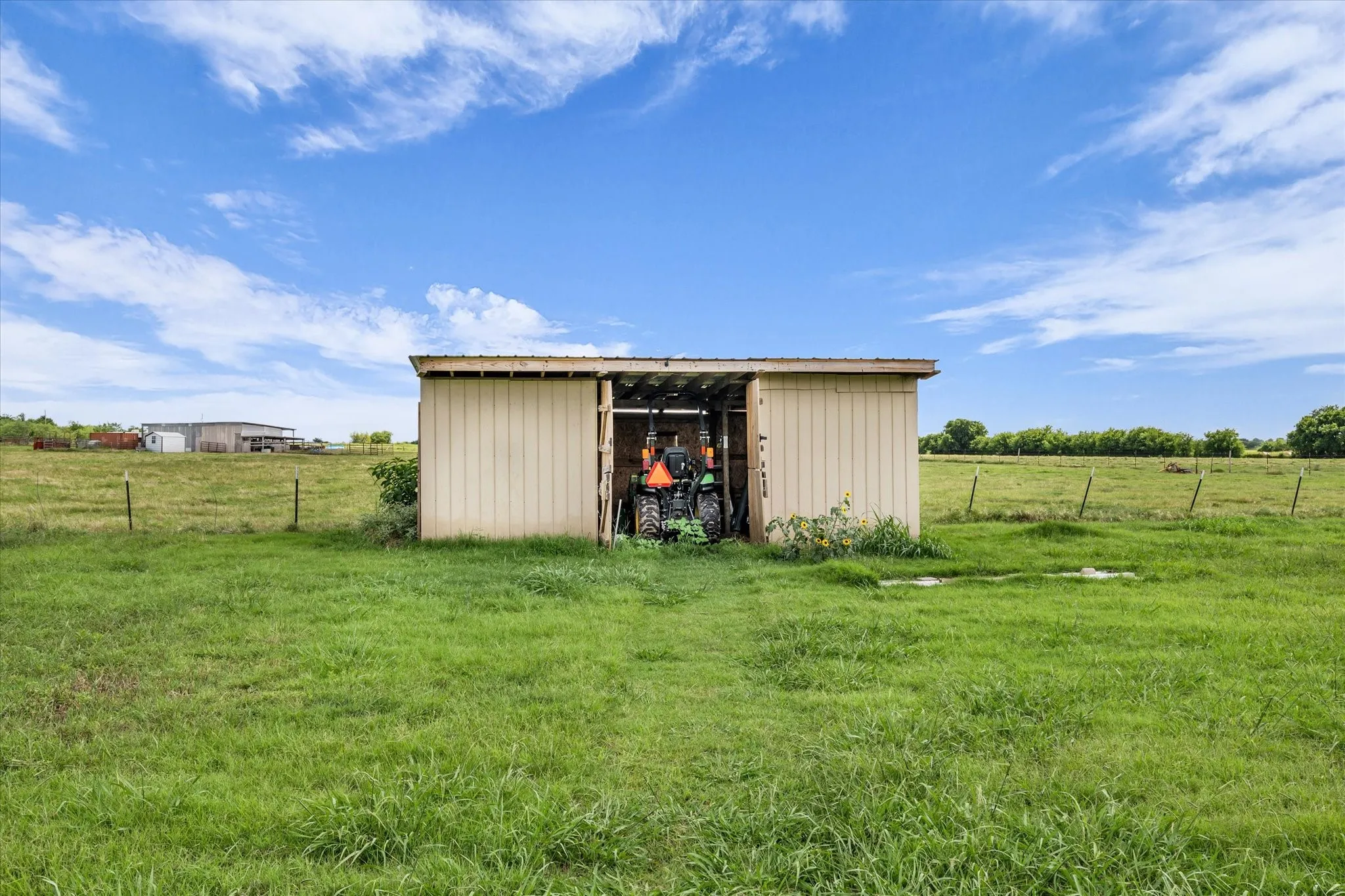 Metal-sided shed with an open bay and a corrugated metal roof