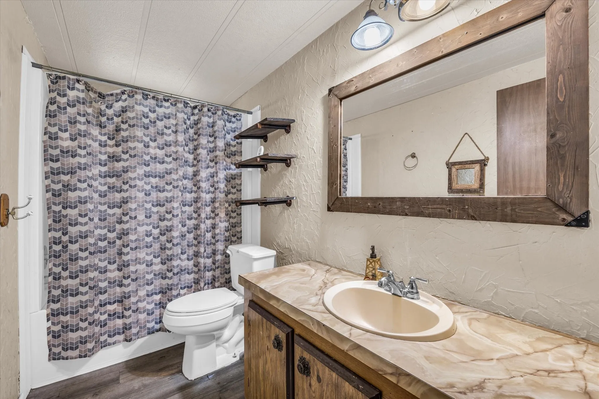 Bathroom vanity with a framed mirror, an integrated sink, and an ornamental faucet