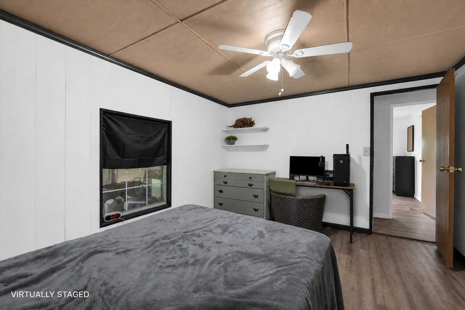 Bedroom featuring a ceiling fan, wood-finish flooring, white walls with black trim, and a window with a black frame