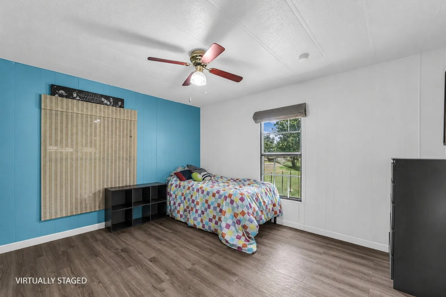 Bedroom featuring wood-finish flooring and a ceiling fan with integrated lighting