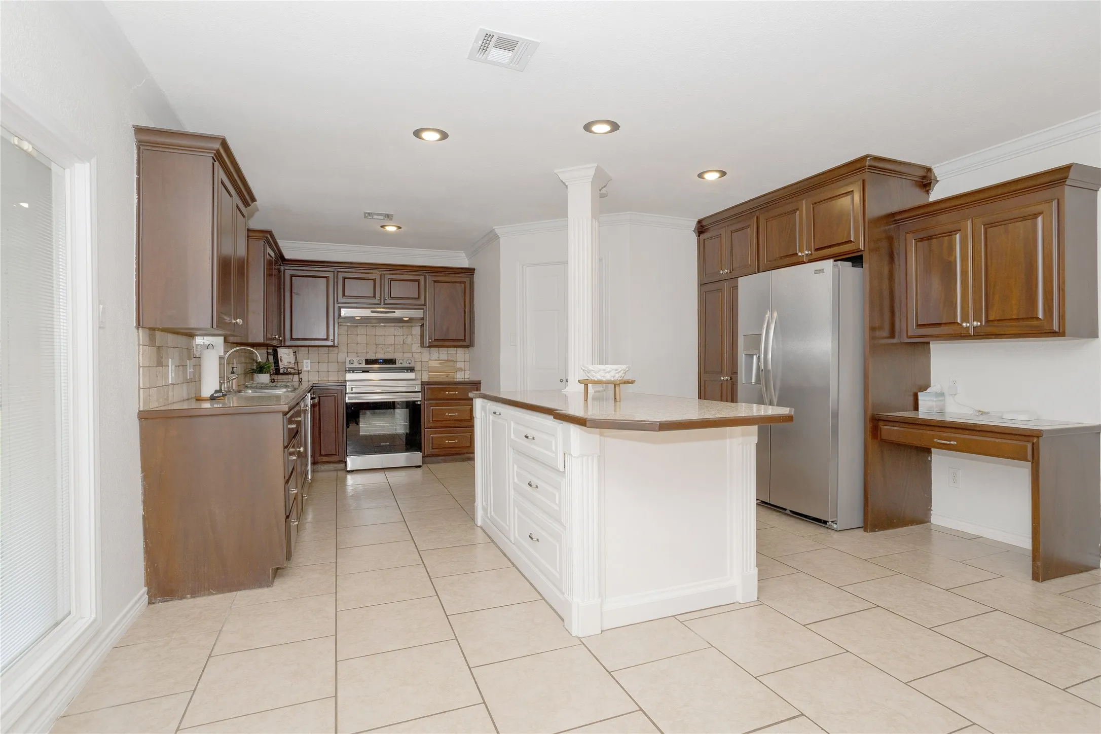 Another view of the kitchen, showing the island and Frigidaire Gallery refrigerator that stays.