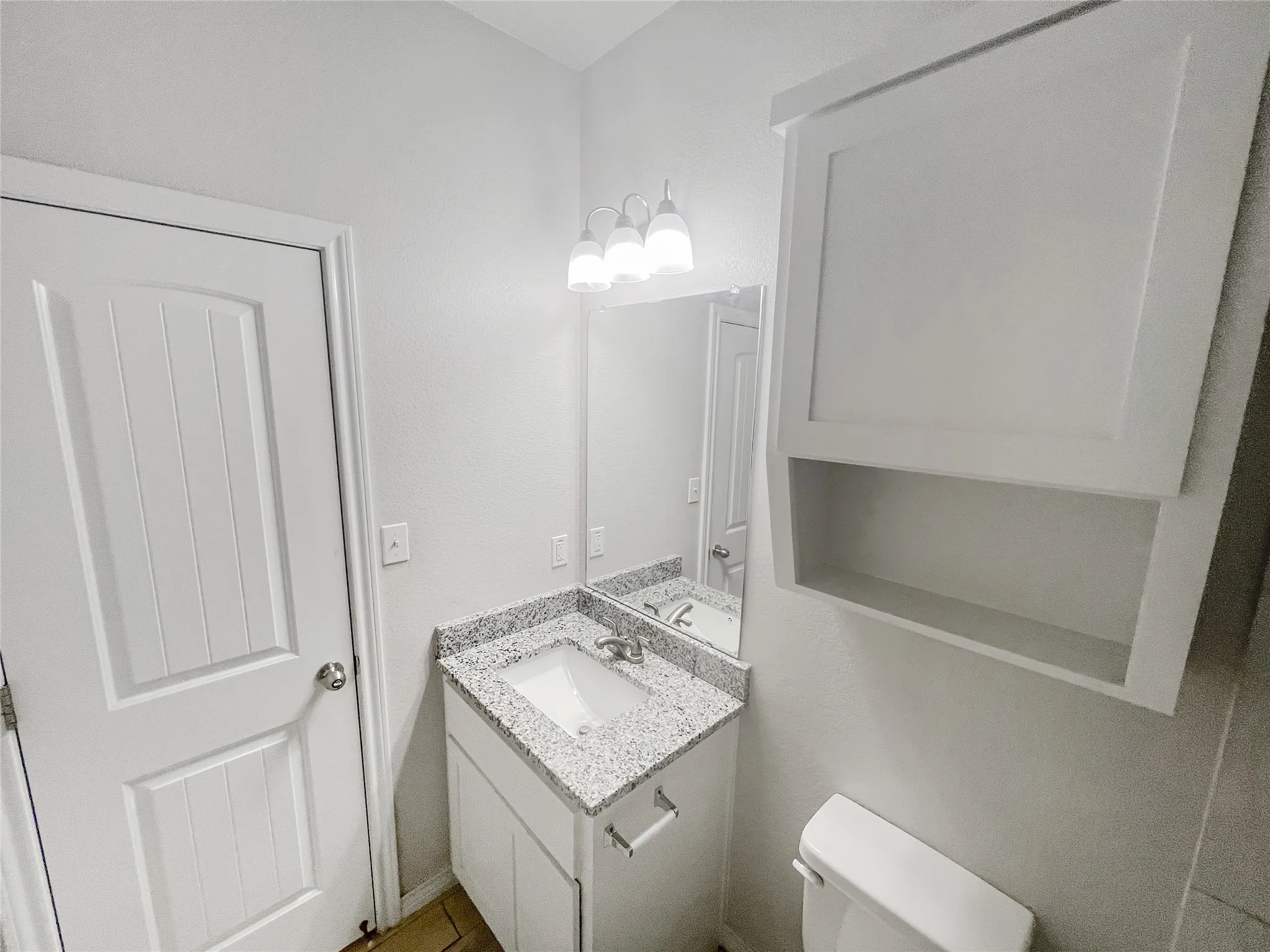 Bathroom vanity with a granite-look countertop and integrated sink