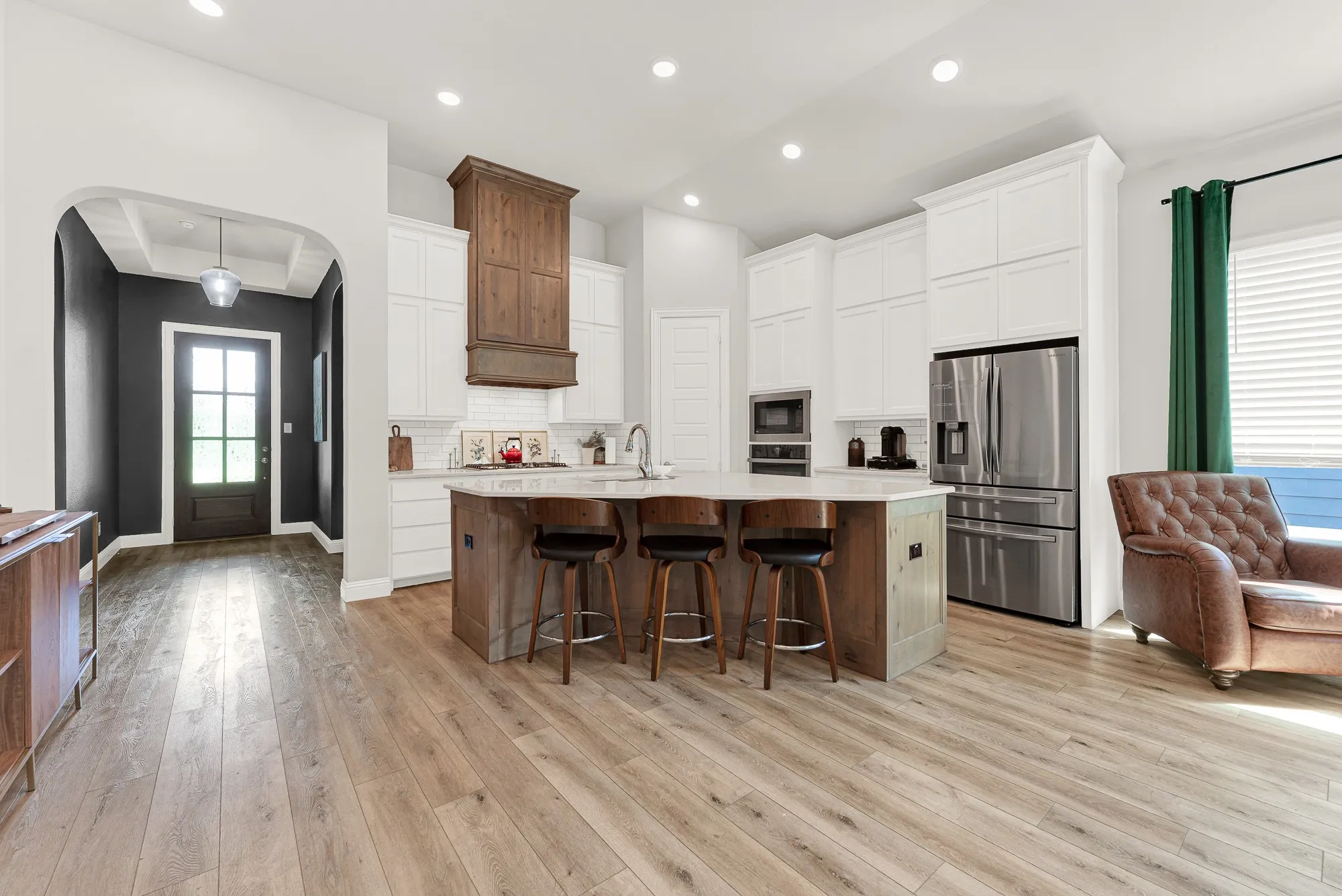 Kitchen with upgraded two-tone cabinetry and large center island, quartz countertops