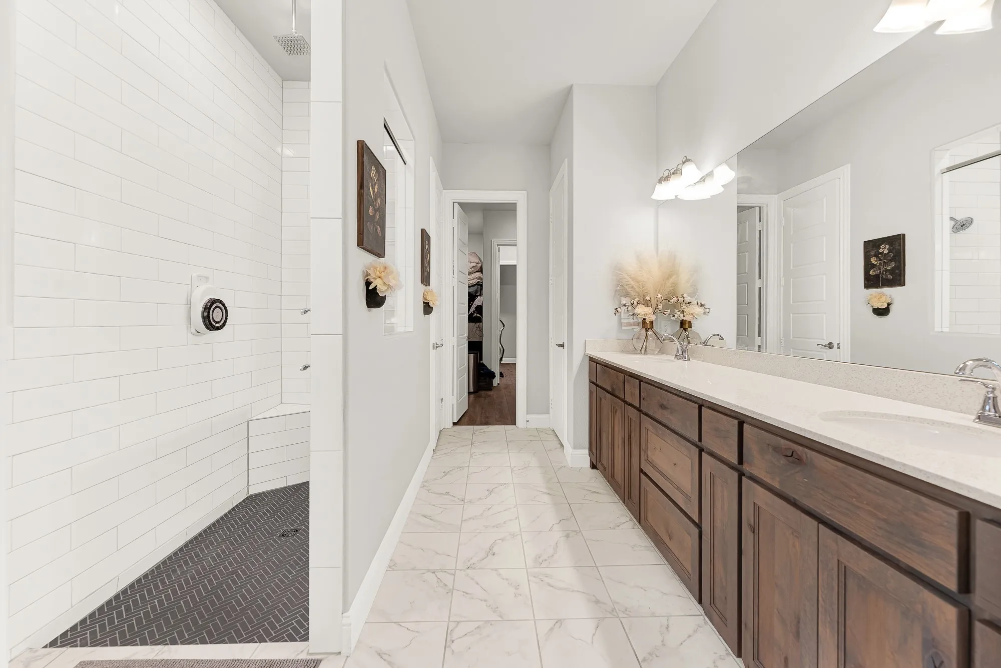 Primary bath with rain shower head and wood-tone cabinetry