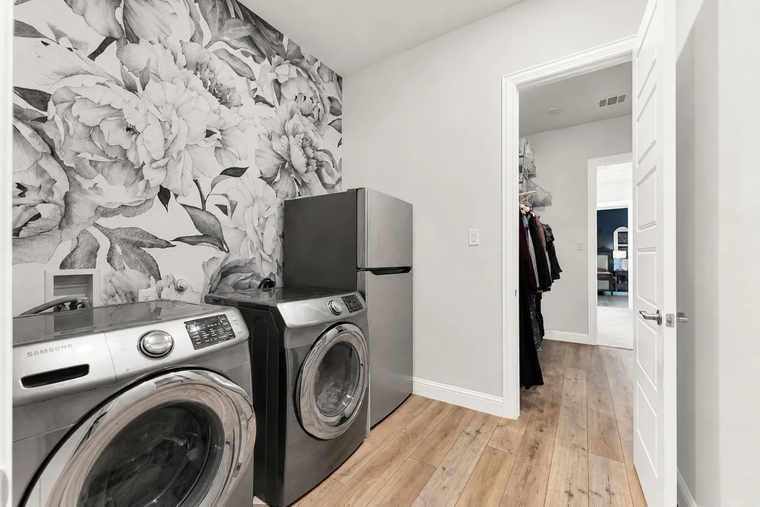 Laundry room with decorative accent wall, direct primary closet access