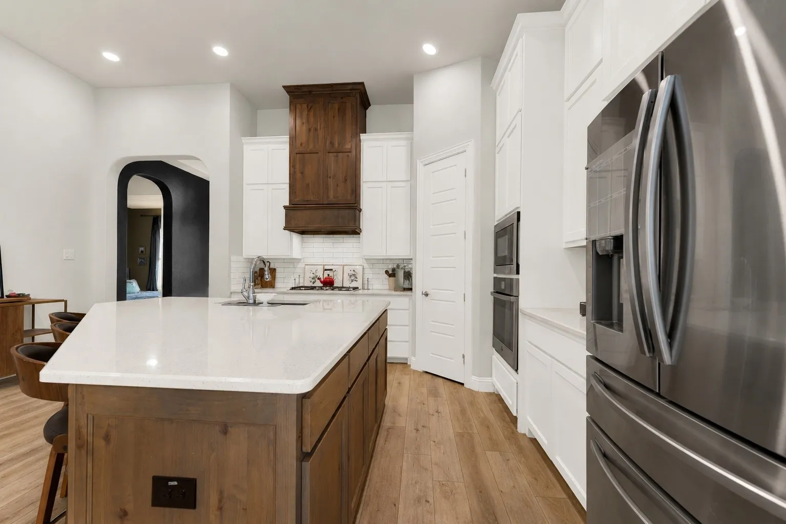 Spacious kitchen island with seating for three, stainless steel refrigerator
