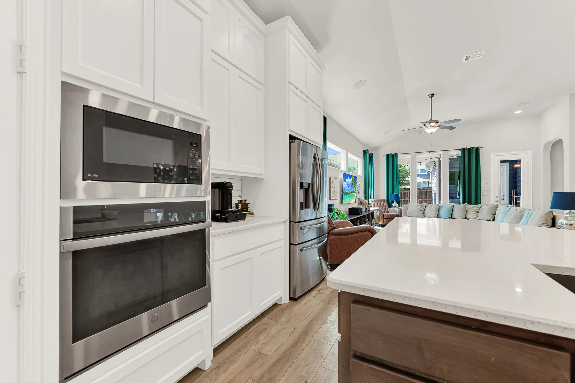 Kitchen with white shaker cabinetry, built-in oven and microwave