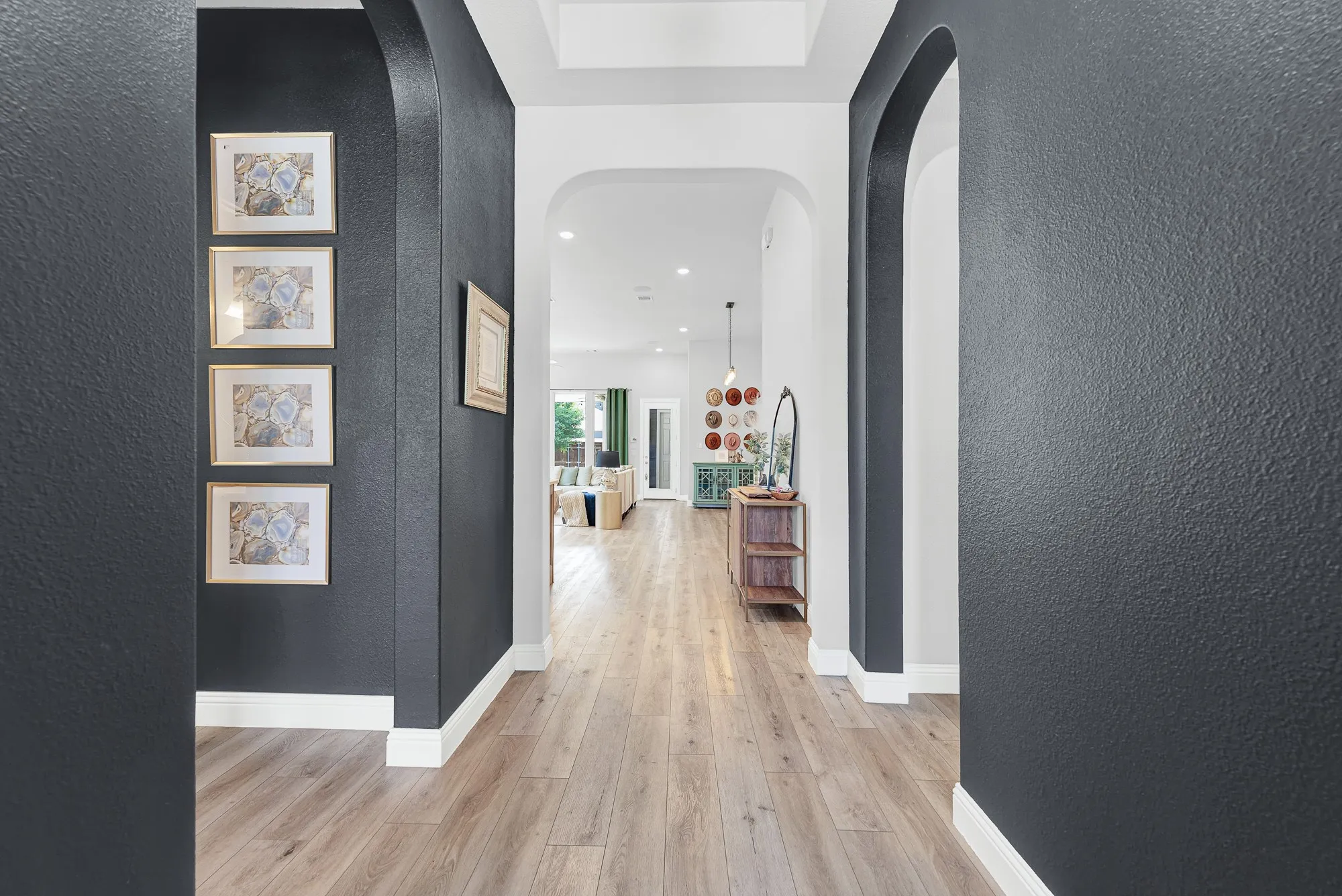 Hallway with LVP flooring and gallery wall, natural light throughout