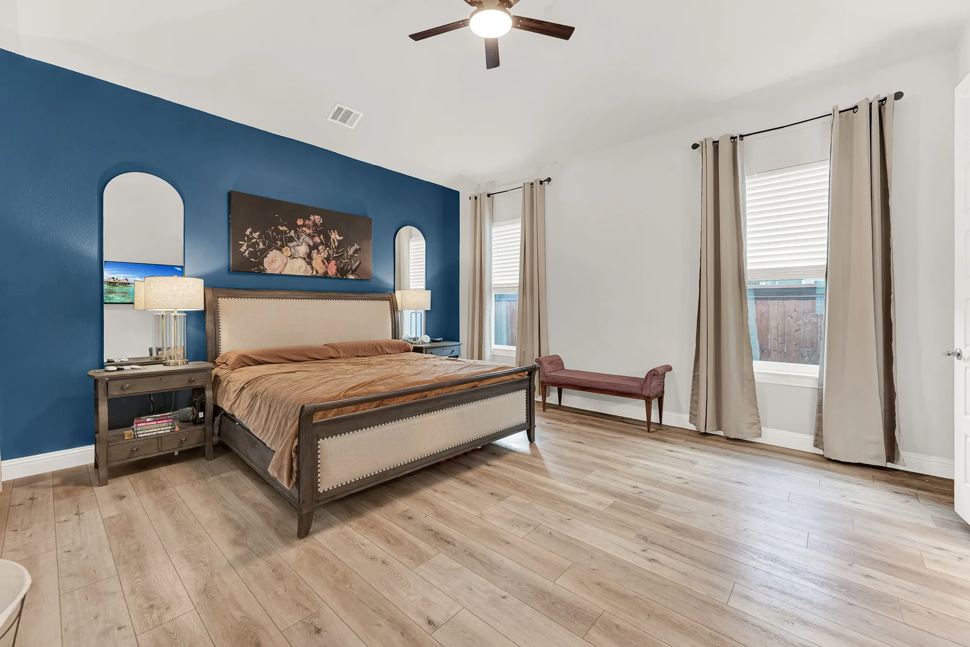 Spacious primary bedroom with LVP flooring and ceiling fan