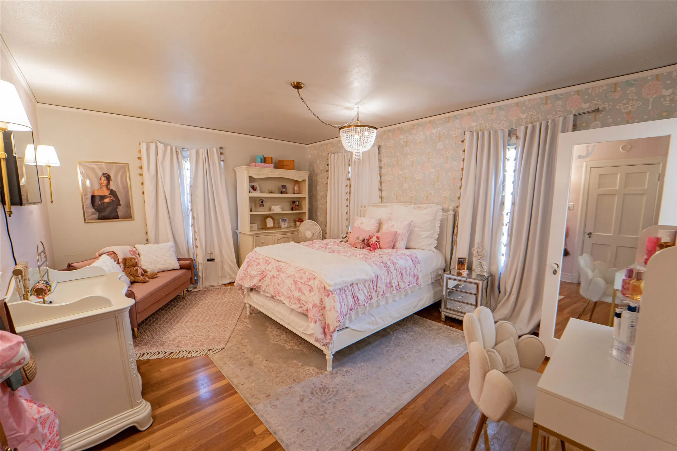 Hardwood flooring throughout featuring a decorative chandelier and wall sconce lighting
