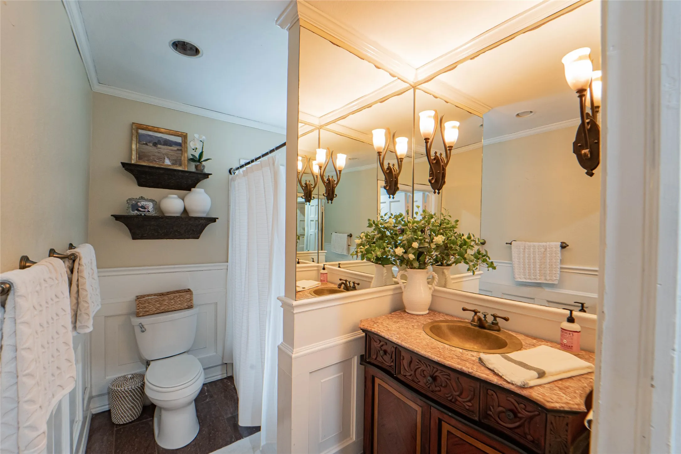 Bathroom featuring a vanity with an integrated basin, a patterned countertop, and an ornate wood-finish cabinet