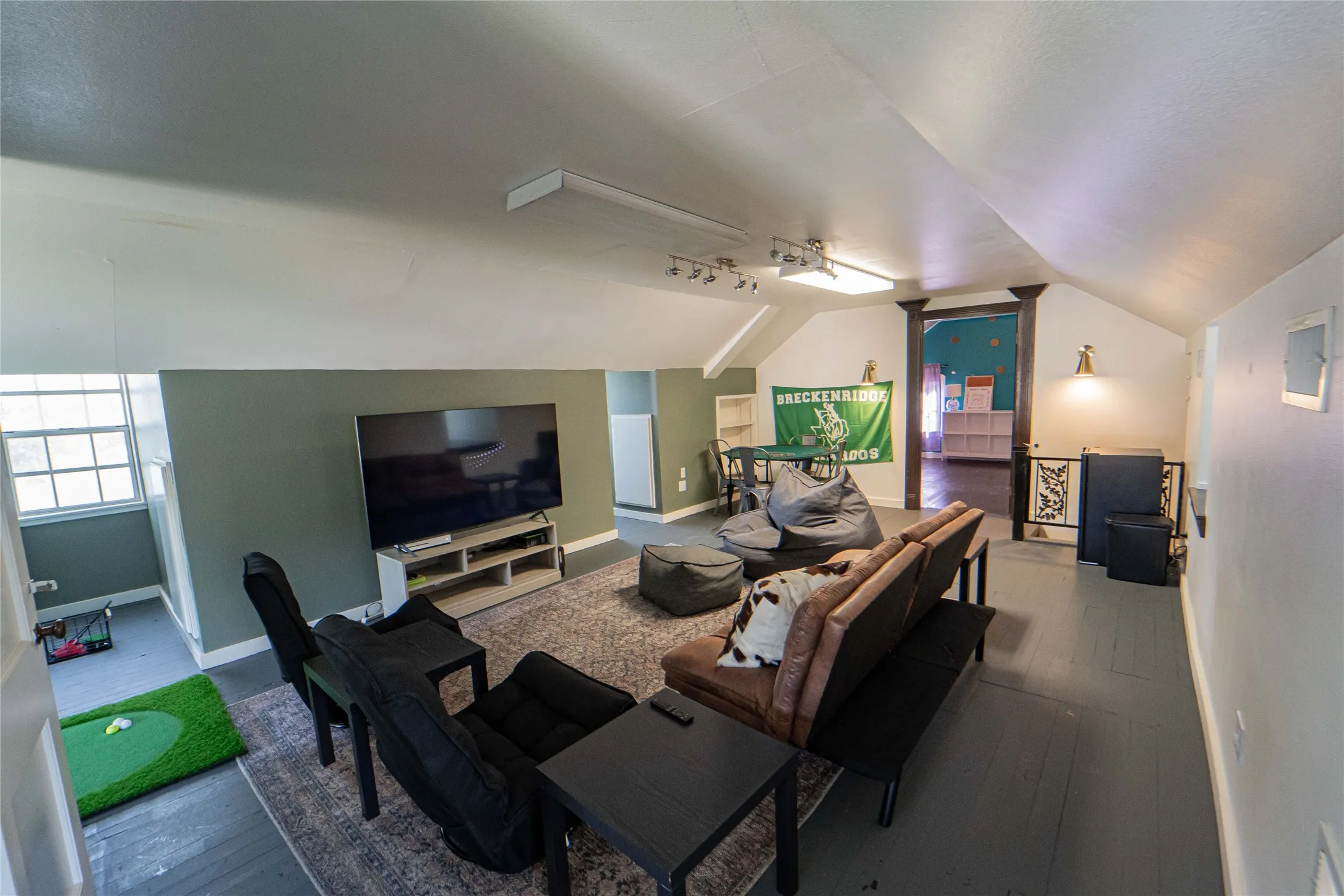 Third story expansive bonus room featuring a sloped ceiling and painted wood-finish flooring