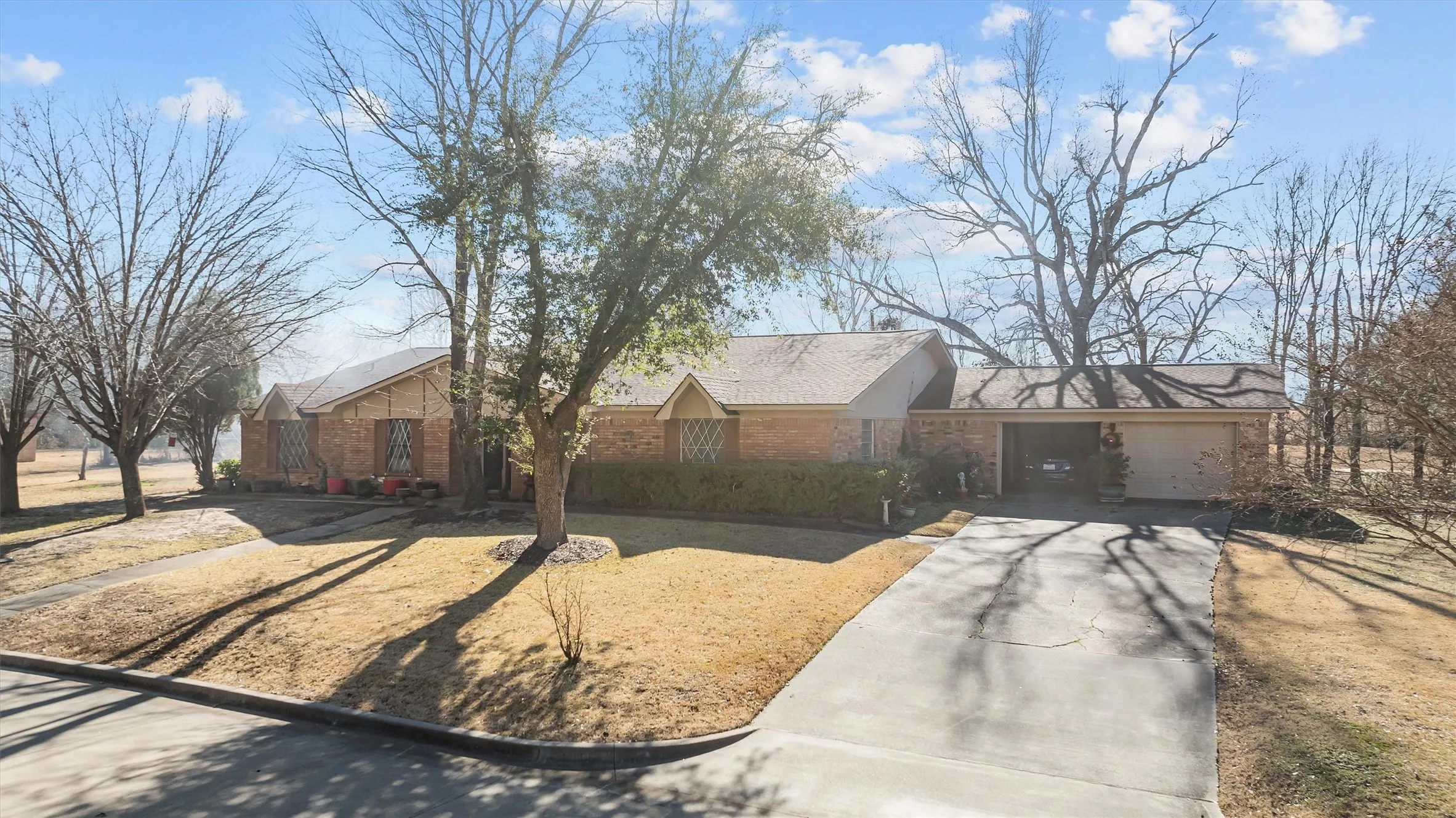 Brick exterior residence featuring a gabled roofline and an attached carport