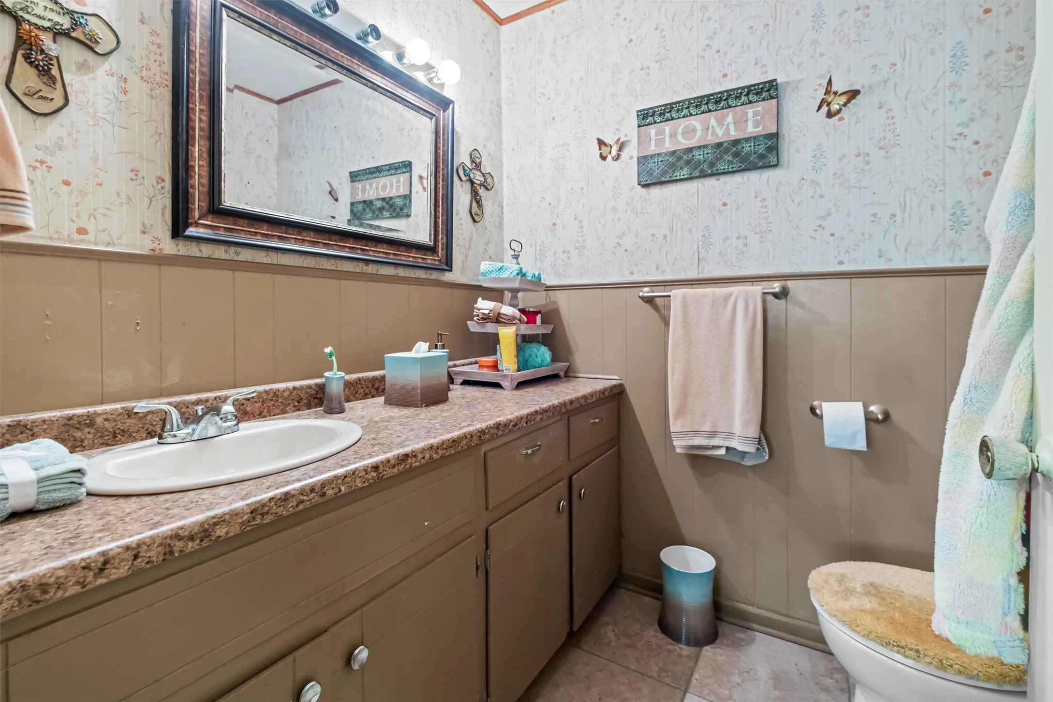 Bathroom vanity featuring an integrated sink, patterned countertop, and wood-finish cabinetry