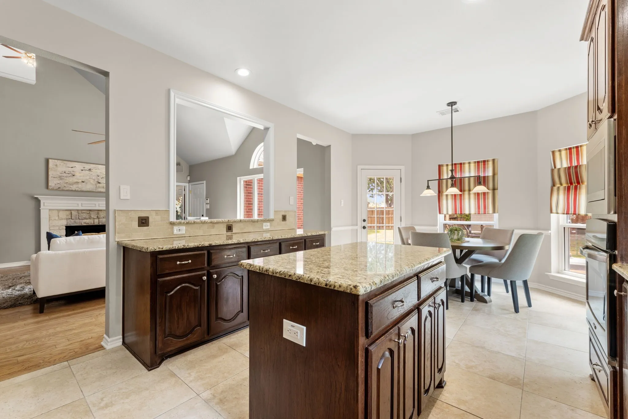 Kitchen featuring a central island with a stone-finish countertop, dark wood cabinetry, and recessed lighting