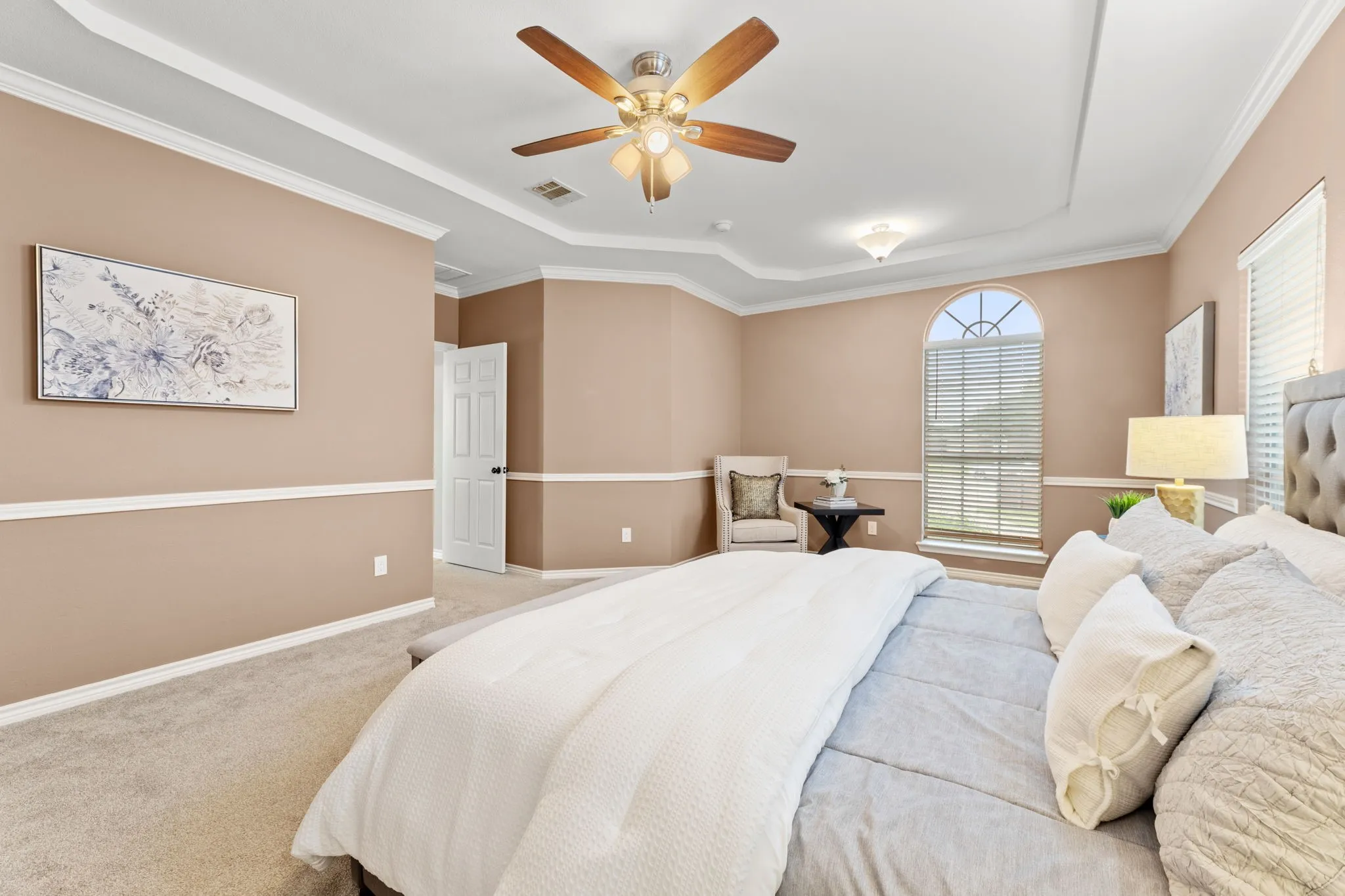 Spacious room with tray ceiling, crown molding, and two-tone wall treatment