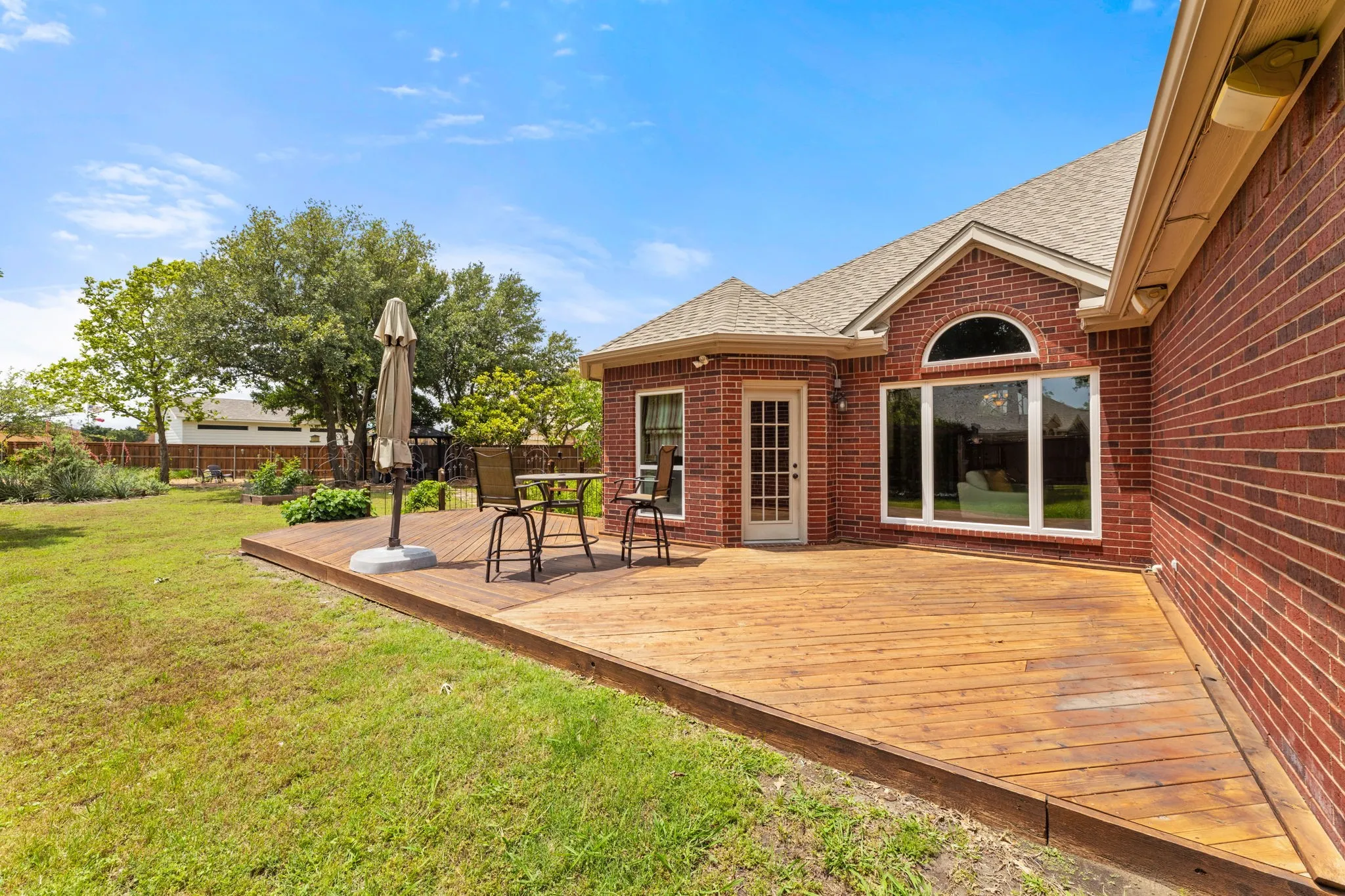 Expansive wood deck with a brick exterior