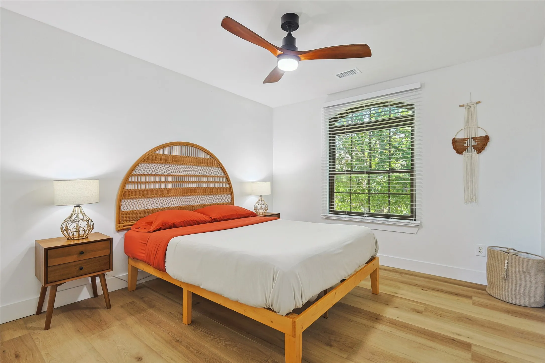 Bedroom with ceiling fan, baseboards, light wood finished floors, and visible vents