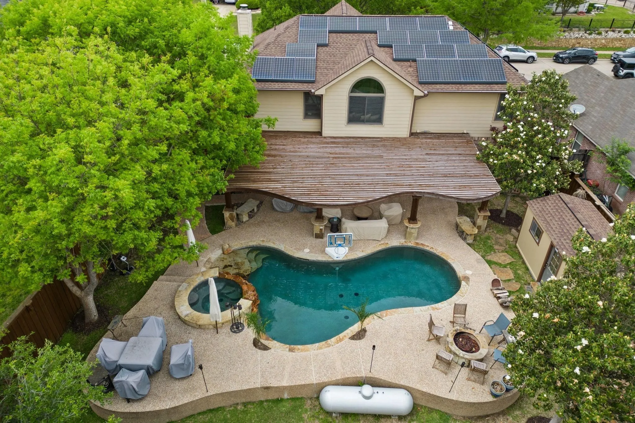 View of swimming pool with a fenced backyard, an outdoor fire pit, a pool with connected hot tub, and a patio area